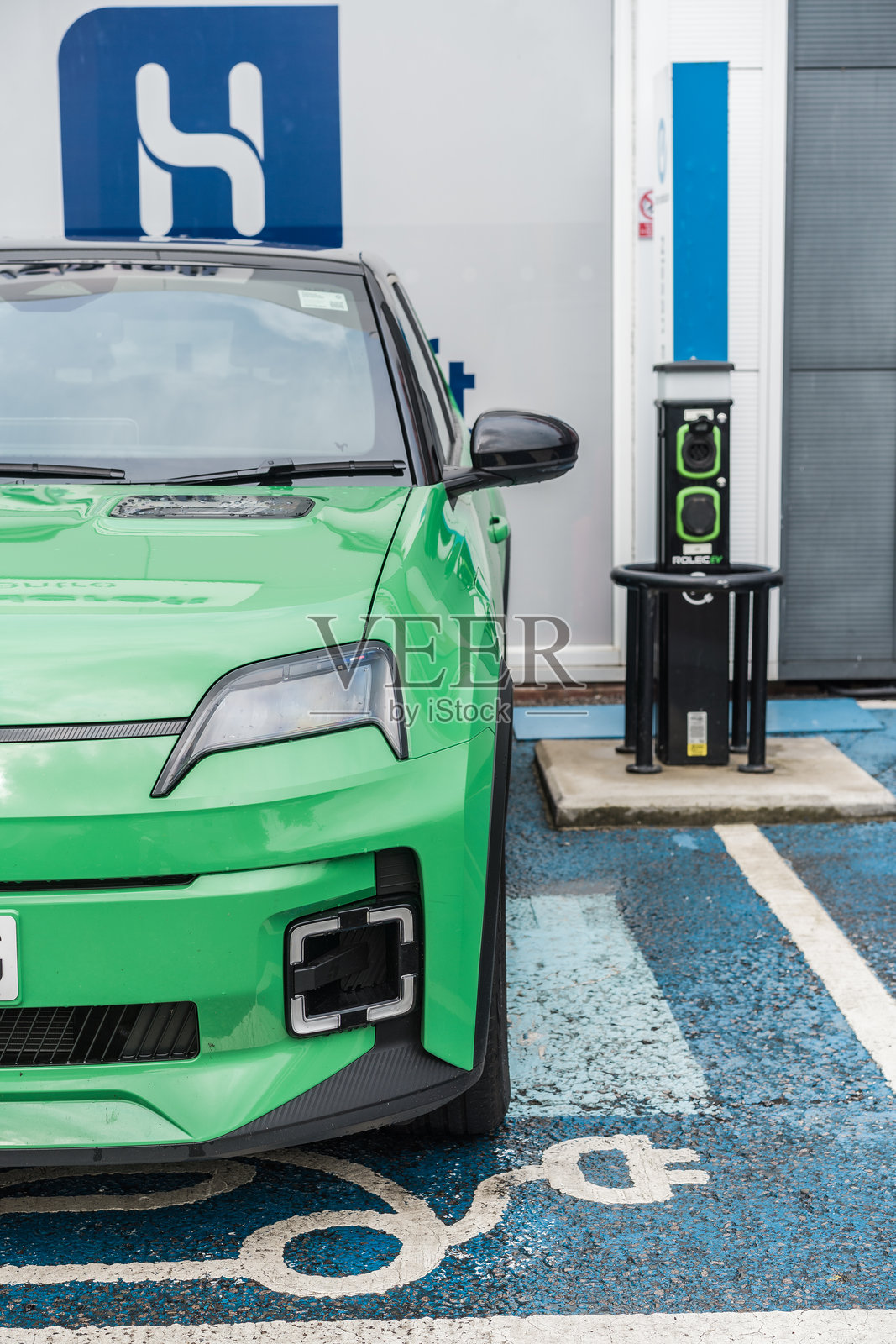 一辆绿色的雷诺5停在电动车充电区。照片摄影图片