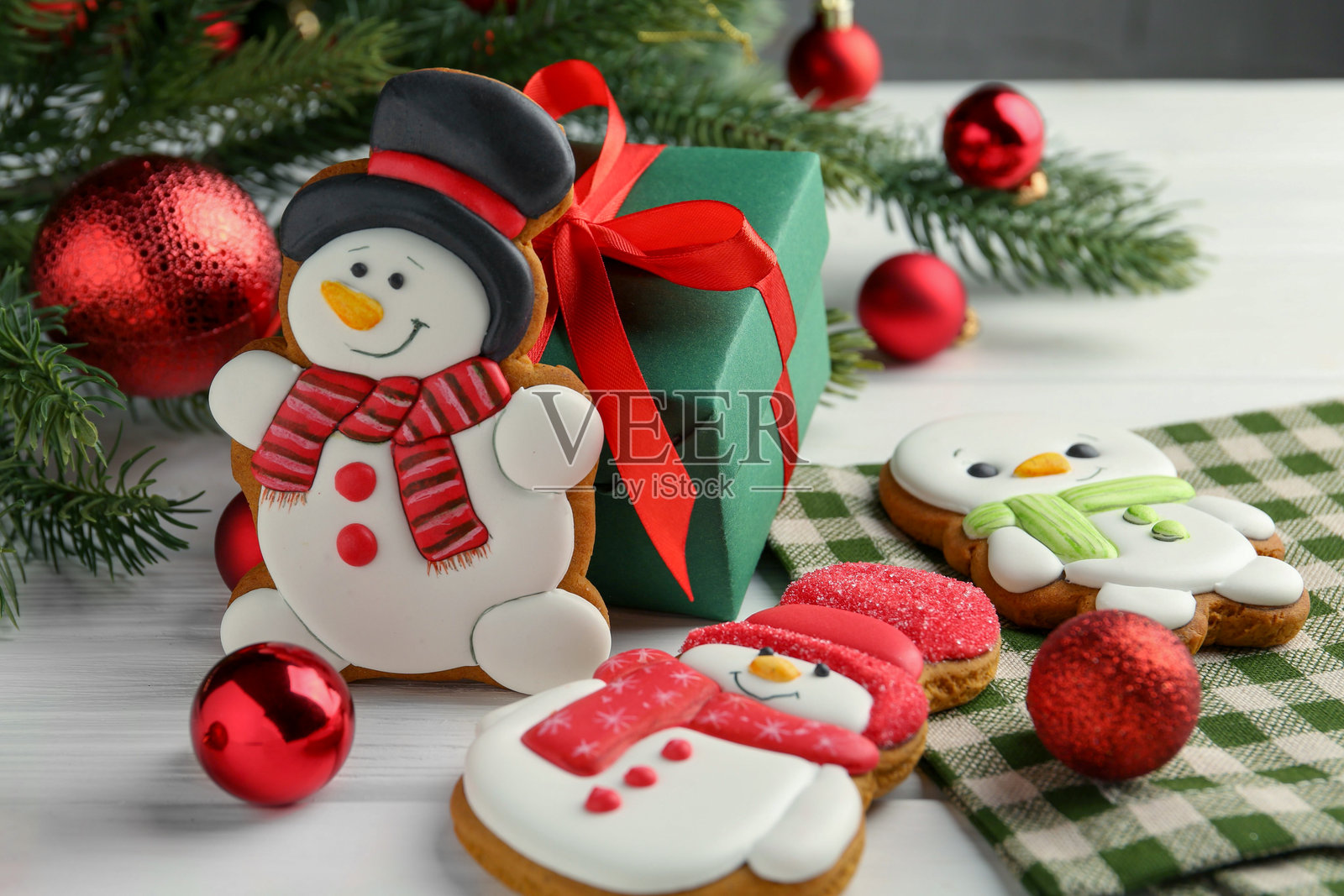 美味的雪人形状饼干和圣诞装饰摆放在白色木桌上，特写镜头照片摄影图片
