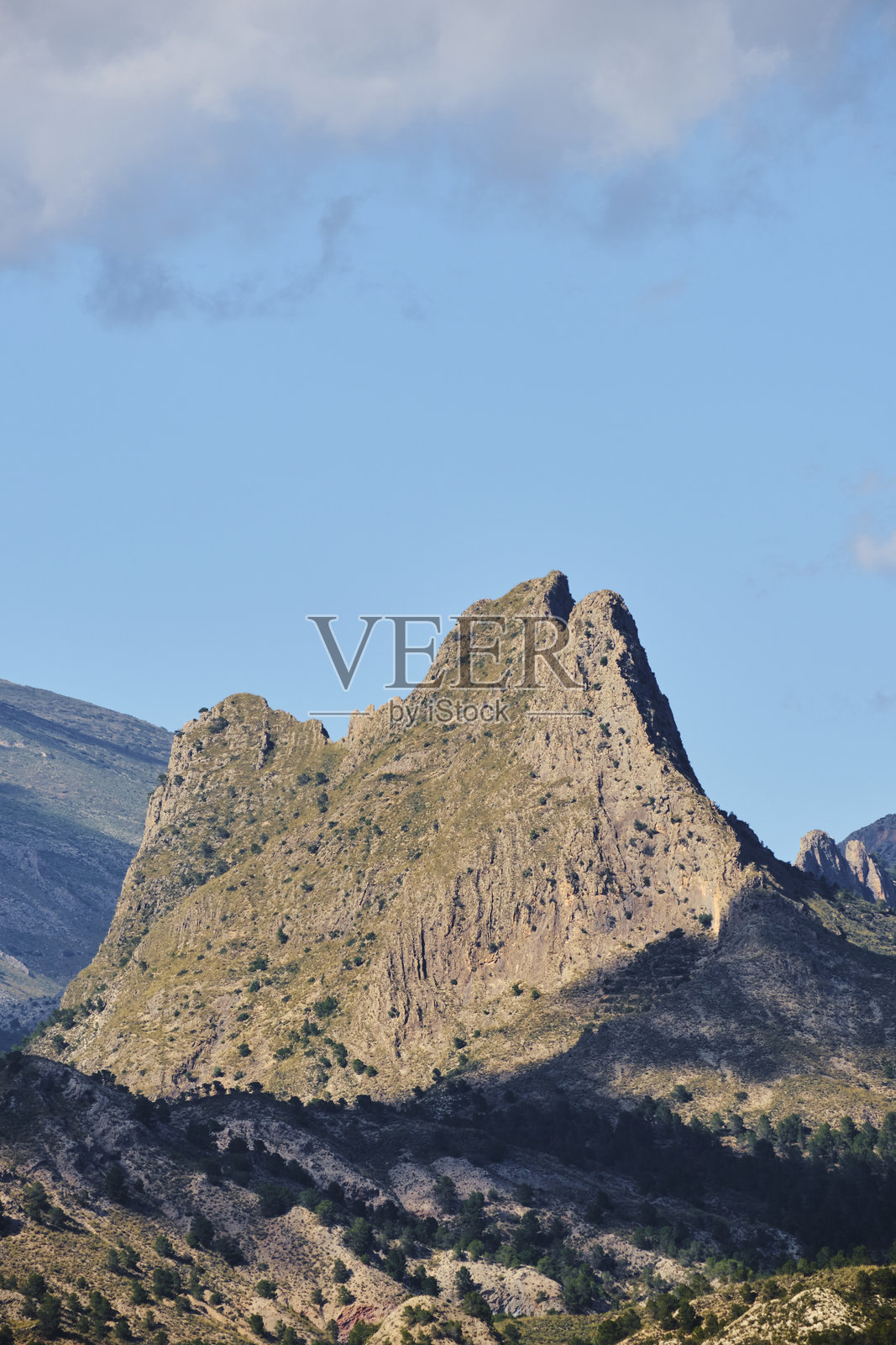 雄伟的山峰在清澈的蓝天和云彩的点缀下显得格外壮观照片摄影图片