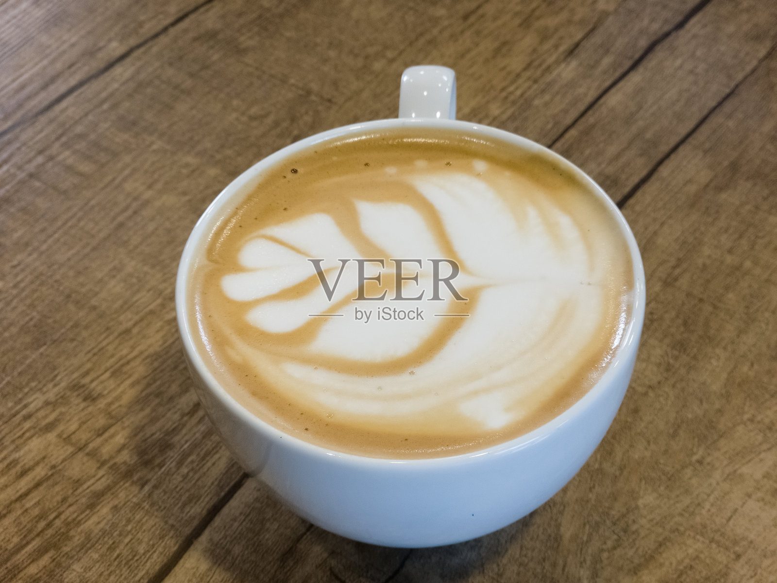 从上方俯视一杯热拿铁，上面有美丽的叶子拉花艺术照片摄影图片