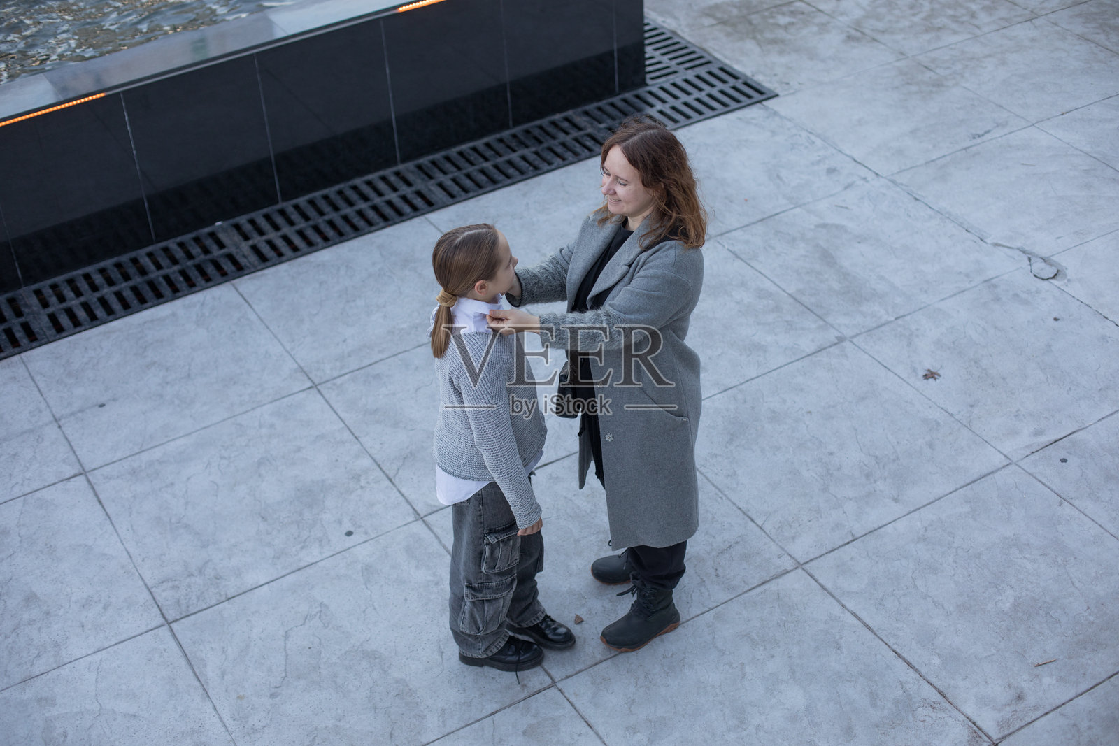 迷人的母亲和她的女儿在户外玩得很开心。幸福的家庭在一起。照片摄影图片