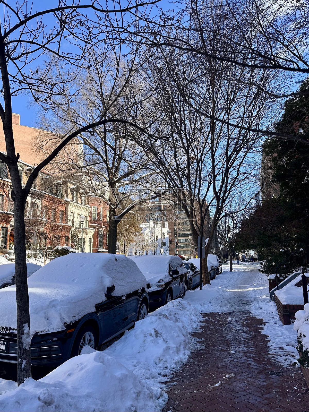 被雪覆盖的街道，两旁停满了汽车照片摄影图片
