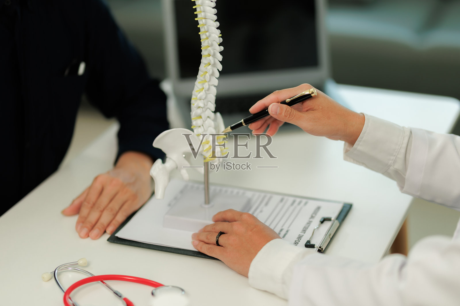 医生与一位背痛患者咨询，提供脊柱护理的指导和治疗方案。照片摄影图片