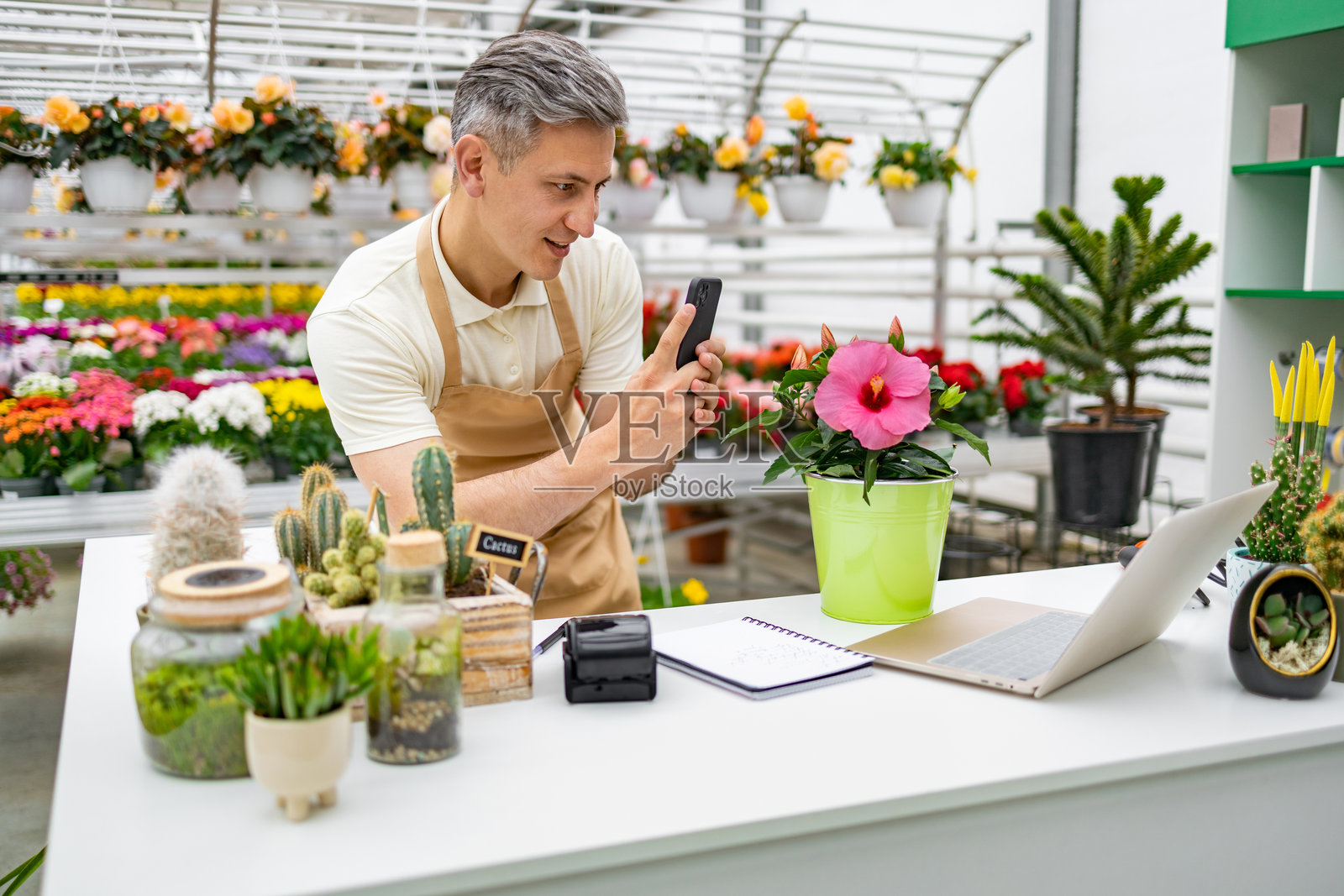 男子在商店拍摄花朵照片摄影图片