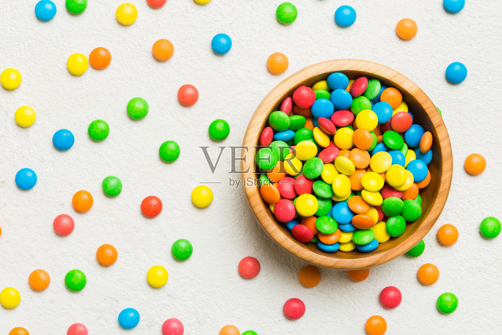 碗中的多彩糖果与彩色背景。生日和节日概念。俯视图，留有空白空间。照片摄影图片