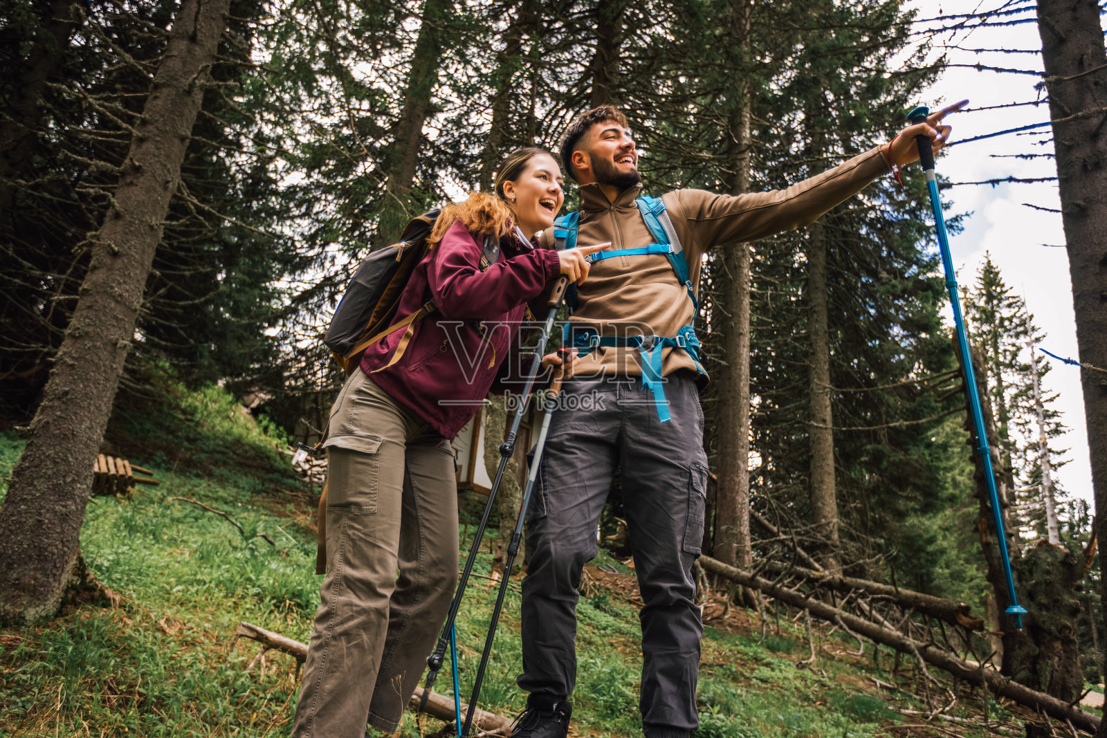 好奇的登山情侣在山林中观察远处的景色照片摄影图片