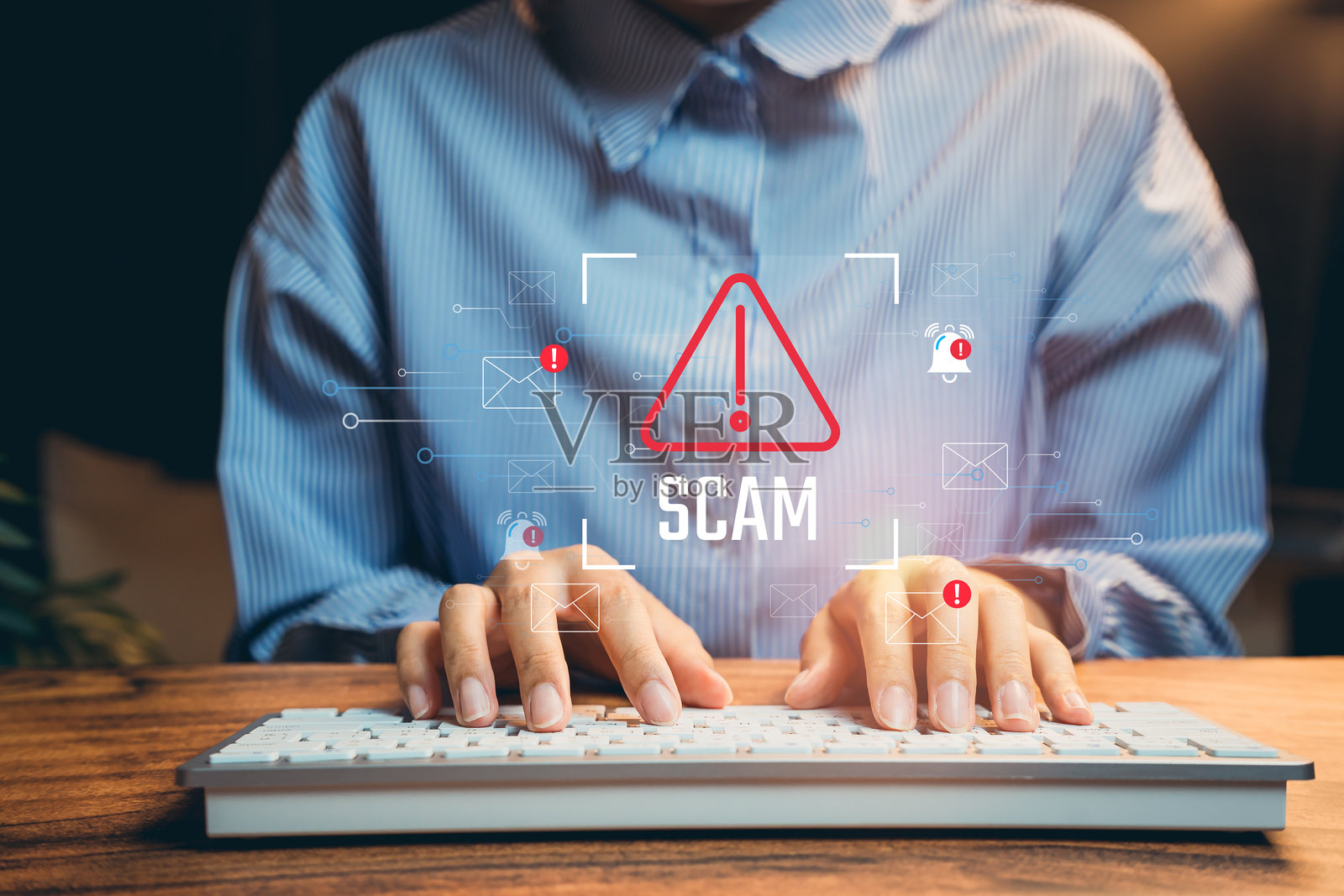 商人双手在键盘上打字，周围有警告标志和提醒，代表在线诈骗检测和网络安全问题。照片摄影图片