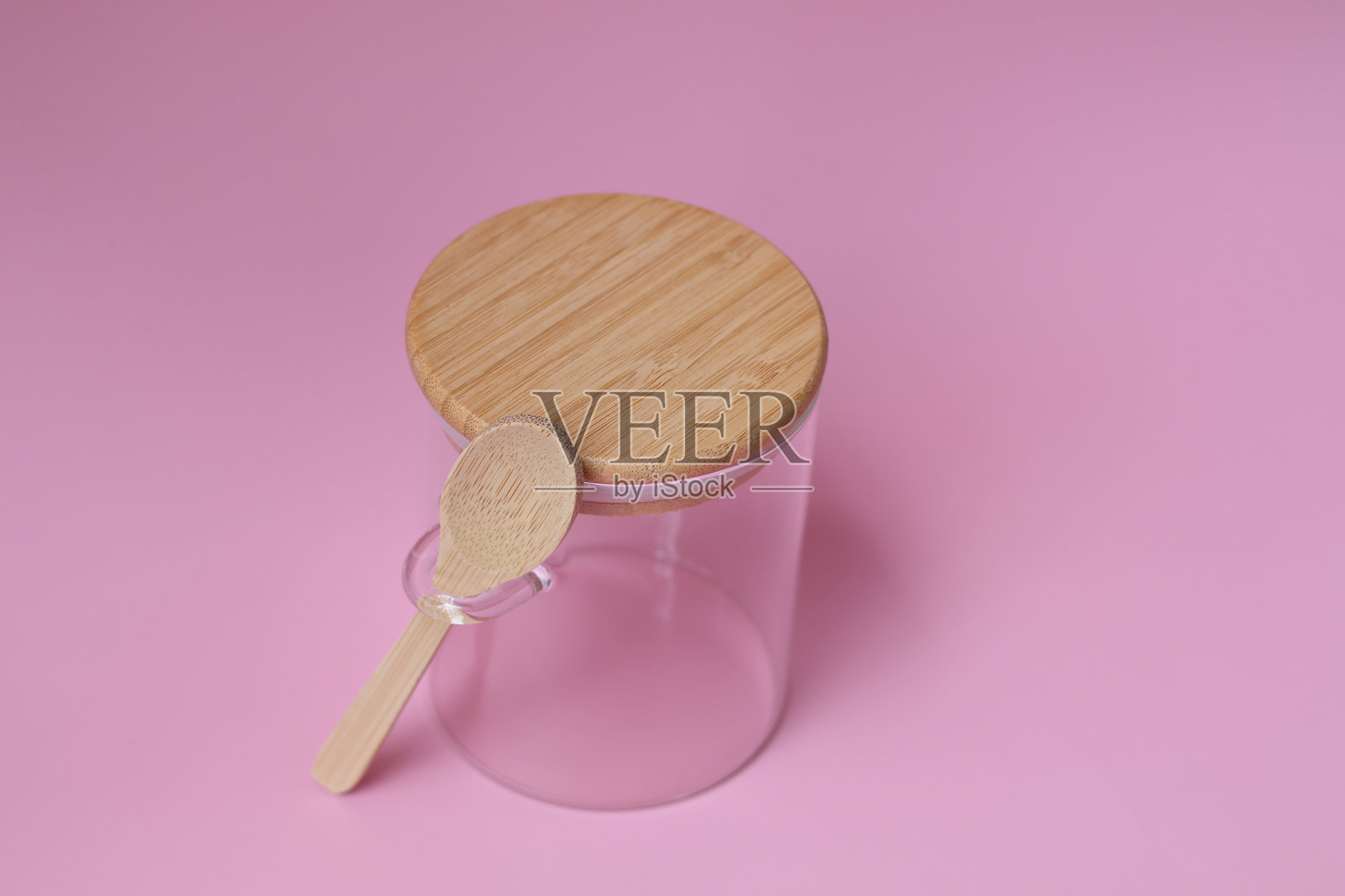 粉色背景上，俯视空玻璃罐和用于食物的勺子。照片摄影图片