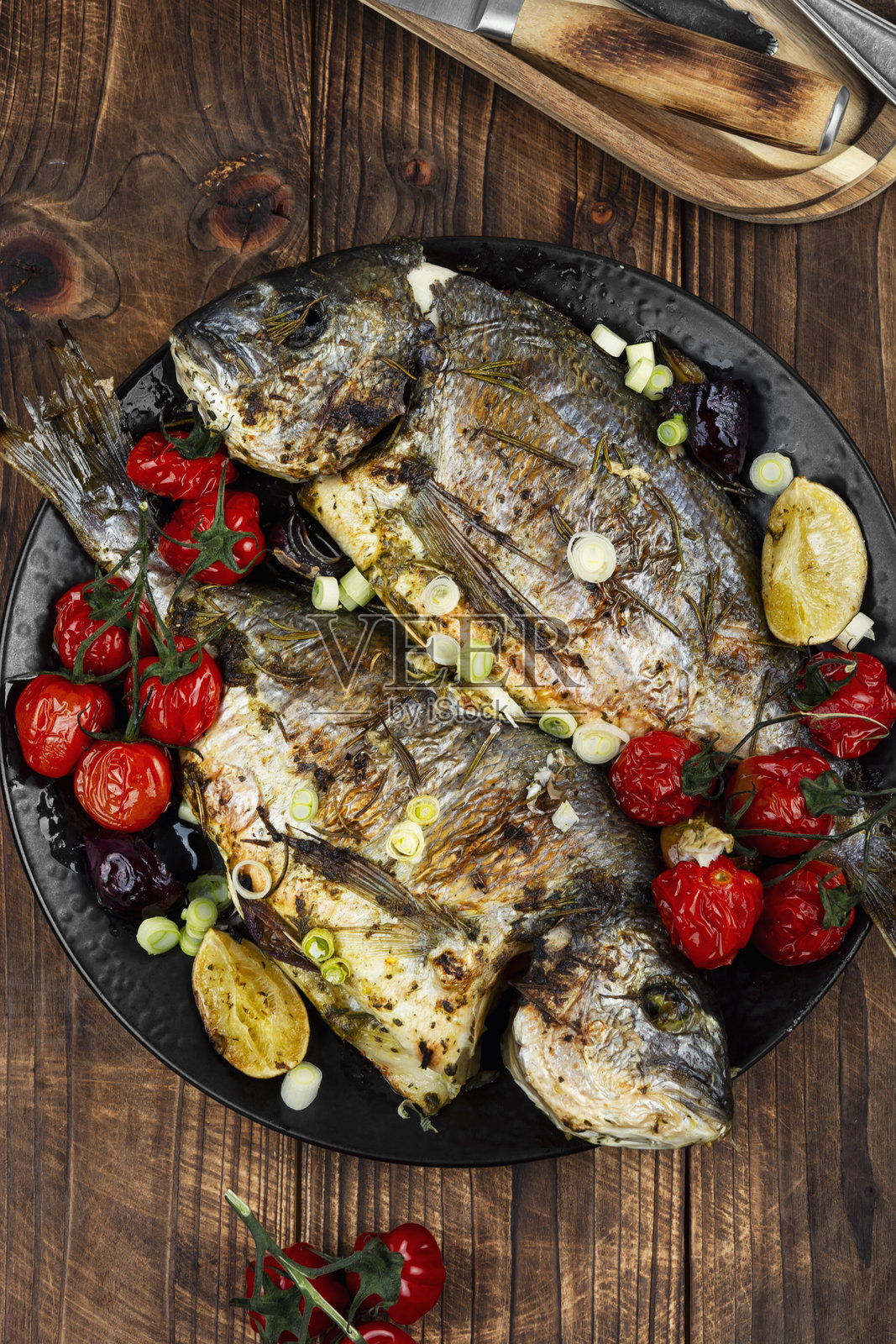 美味的烤金鲷鱼配上色彩鲜艳的蔬菜。照片摄影图片