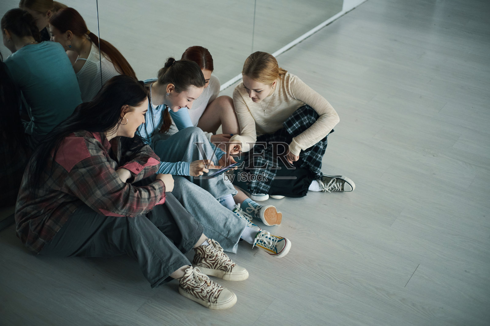 一群青少年女孩放松并分享智能手机照片摄影图片