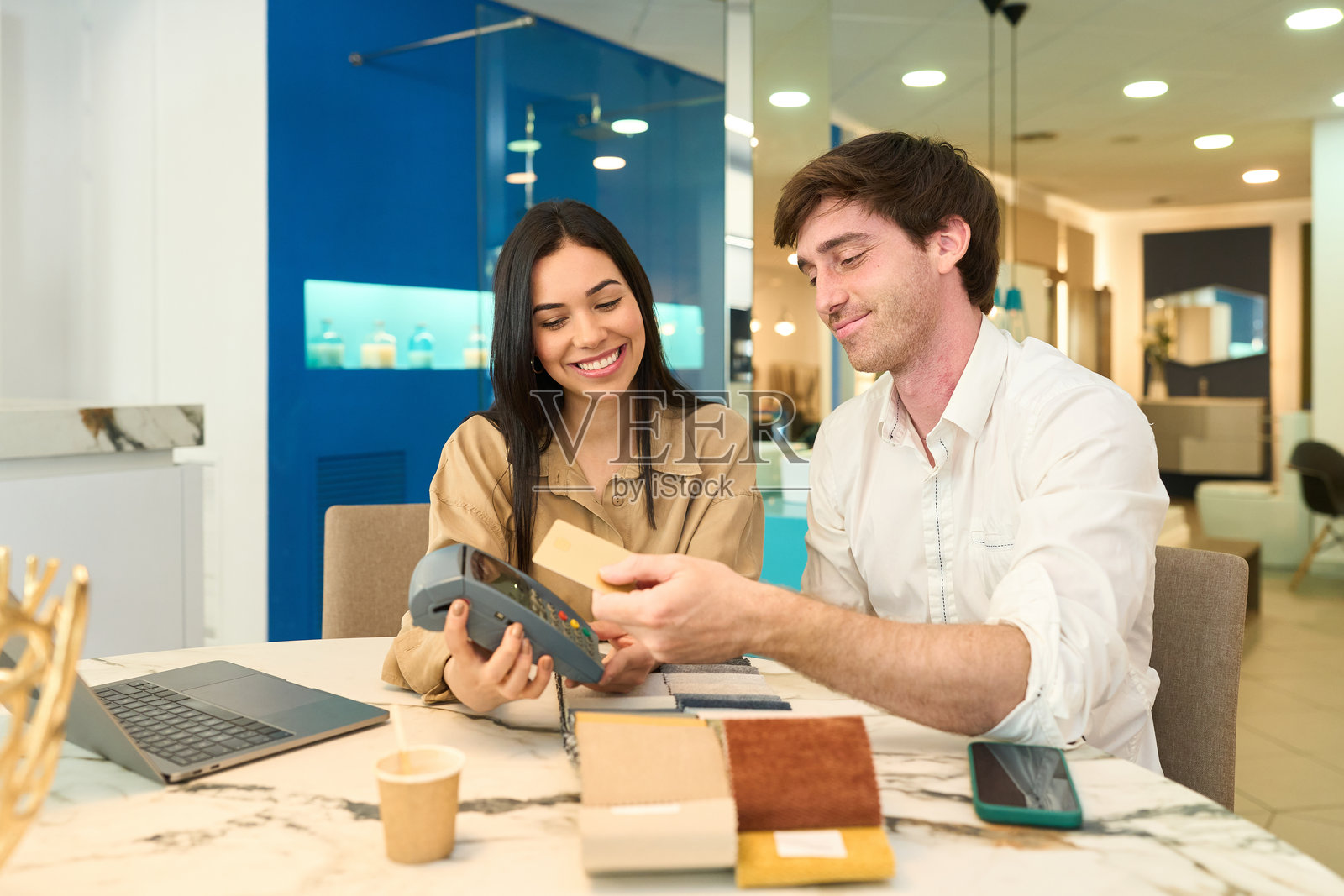 情侣在展厅用非接触式卡支付家具费用照片摄影图片