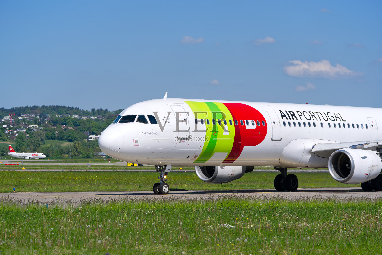 侧面视角的葡萄牙航空公司TAP的空客A321-211，注册号CS-TJF，在阳光明媚的春天，正在苏黎世克洛滕机场滑行至跑道。照片摄影图片