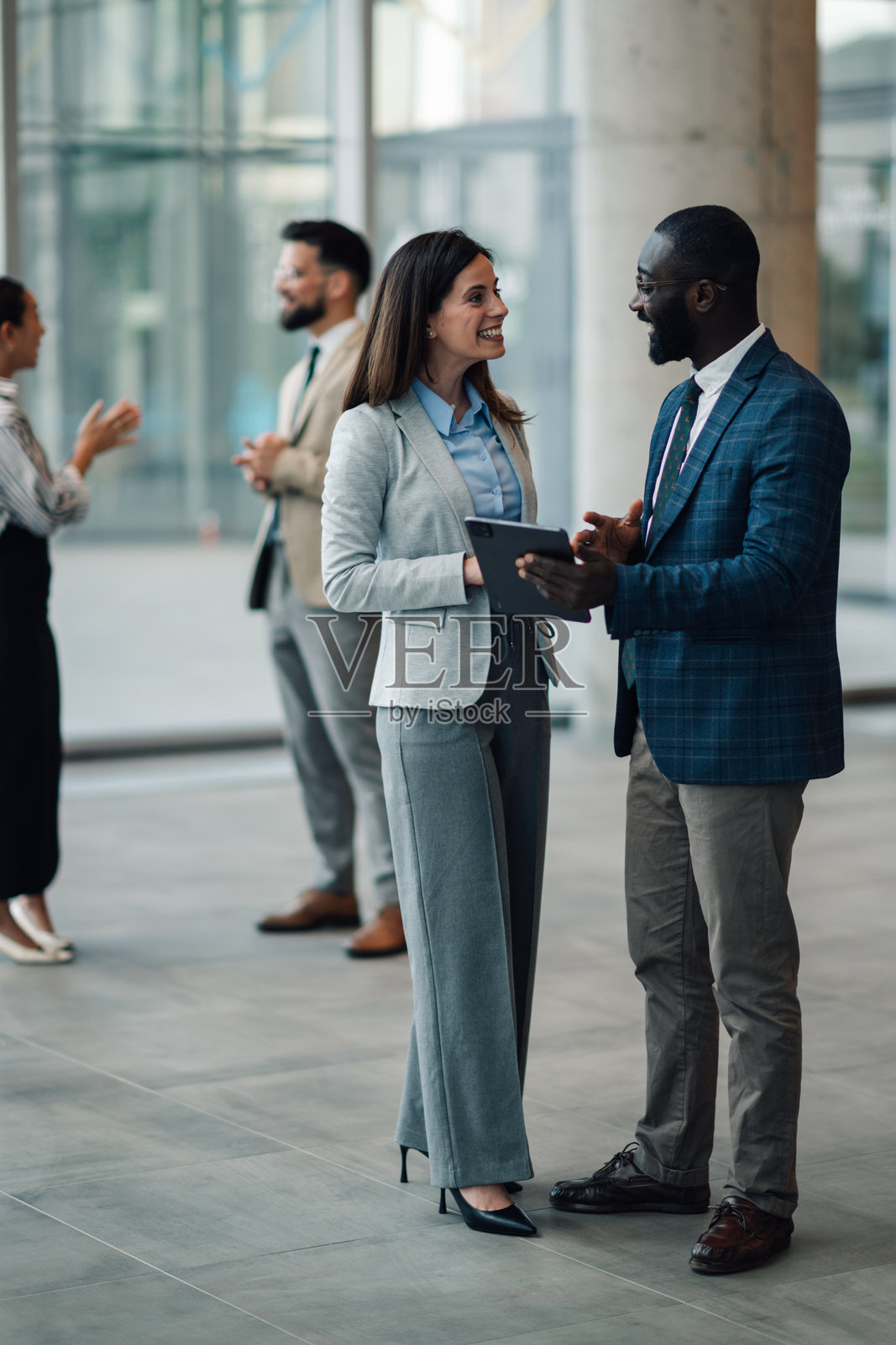 商务人士在办公室大堂使用平板电脑讨论照片摄影图片