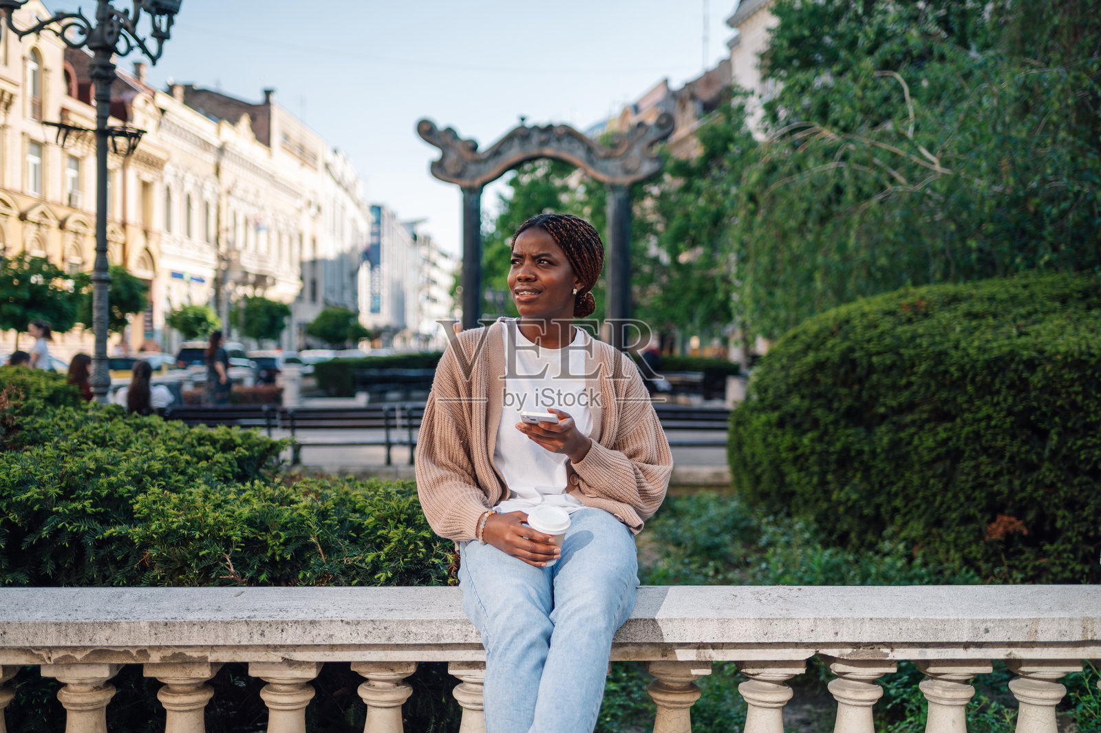 年轻女性在城市公园享受咖啡和手机时光照片摄影图片
