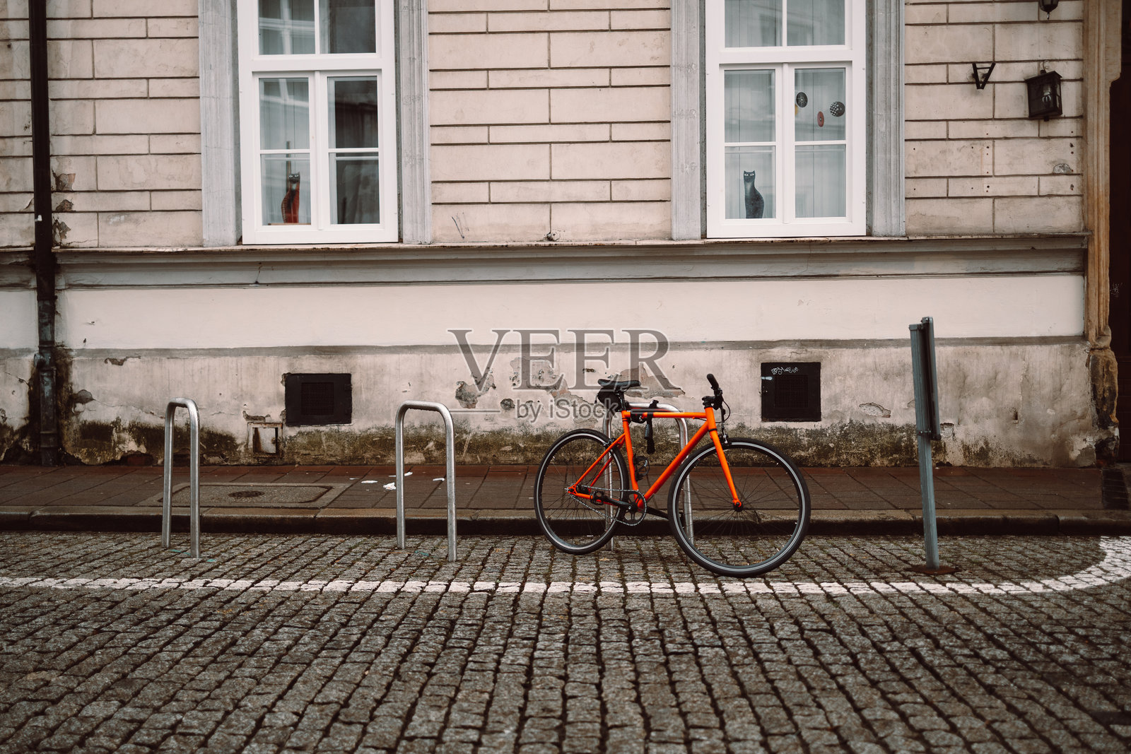 停在鹅卵石街道上的橙色自行车照片摄影图片