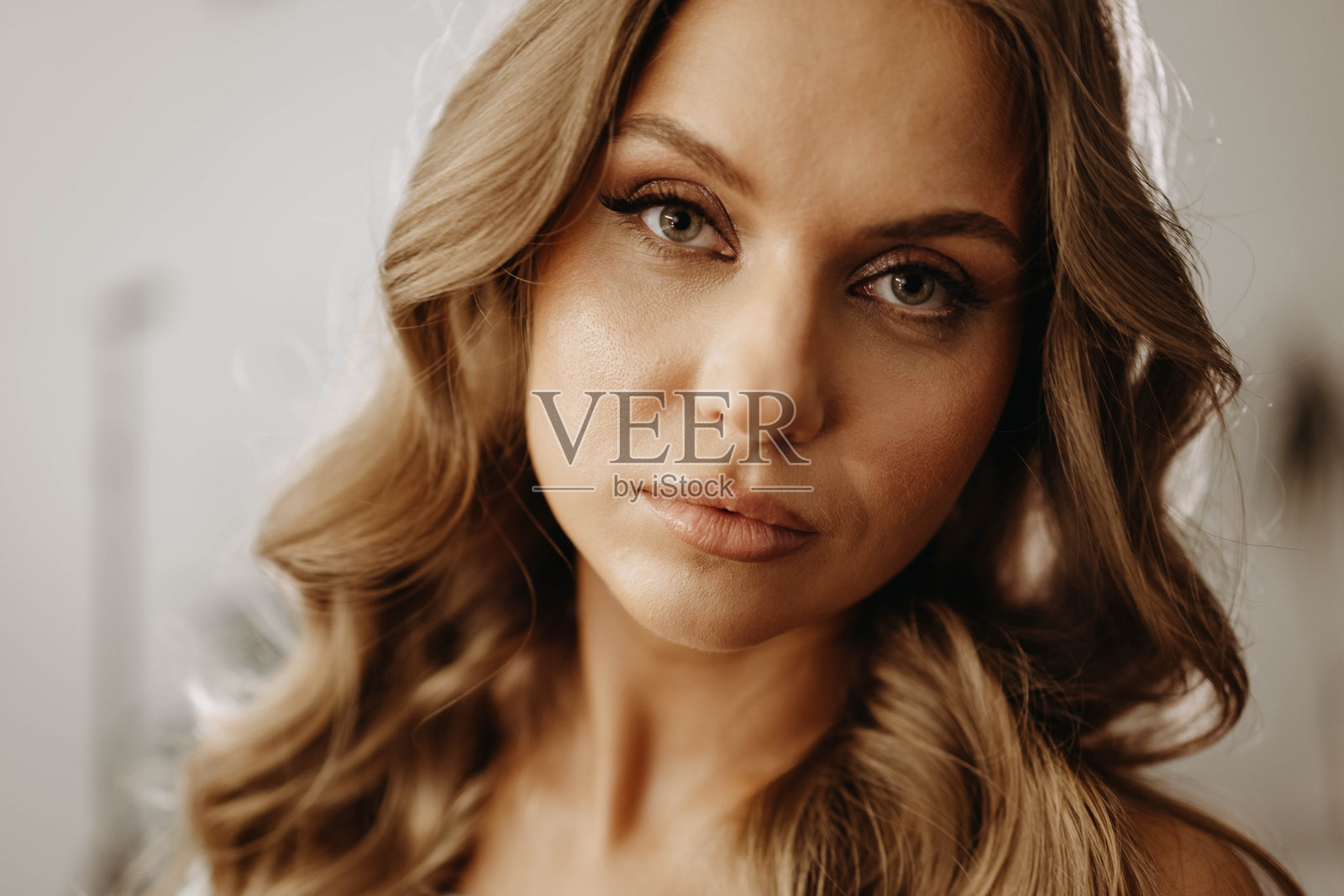 迷人年轻女性的肖像，波浪形的头发。模特富有表现力地看着镜头。特写镜头照片摄影图片