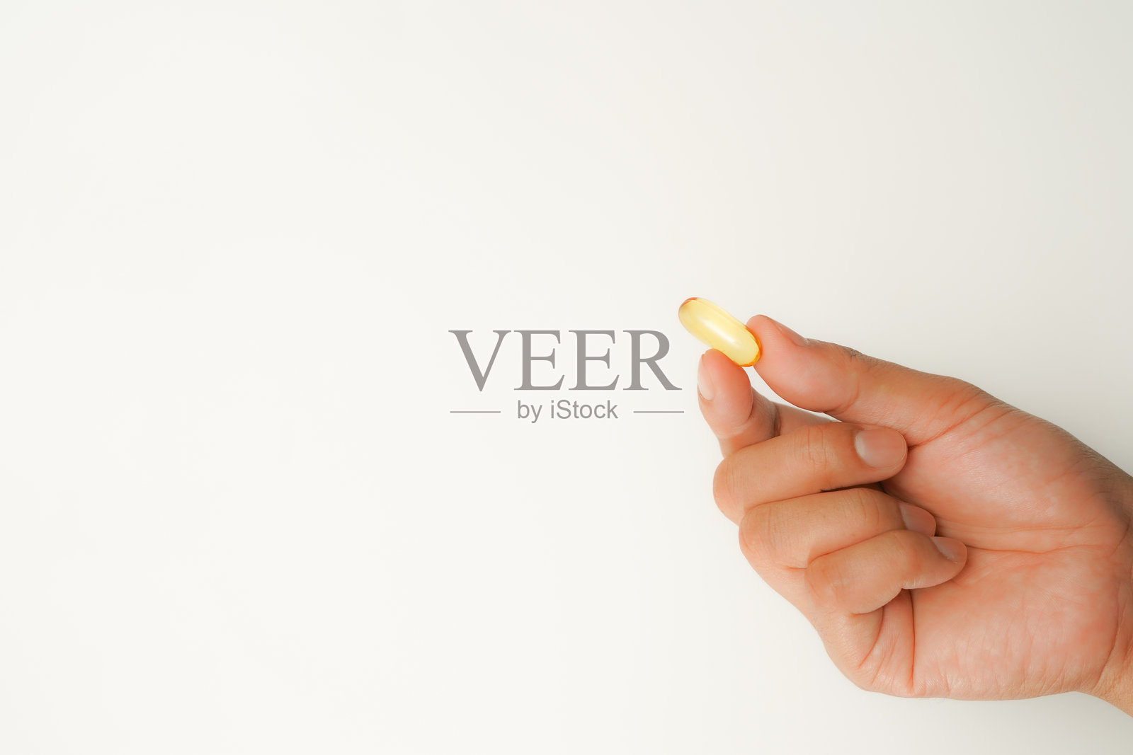 男性手握软胶囊，鱼油胶囊，Omega 3，Omega 9，维生素D，维生素E，补充剂照片摄影图片