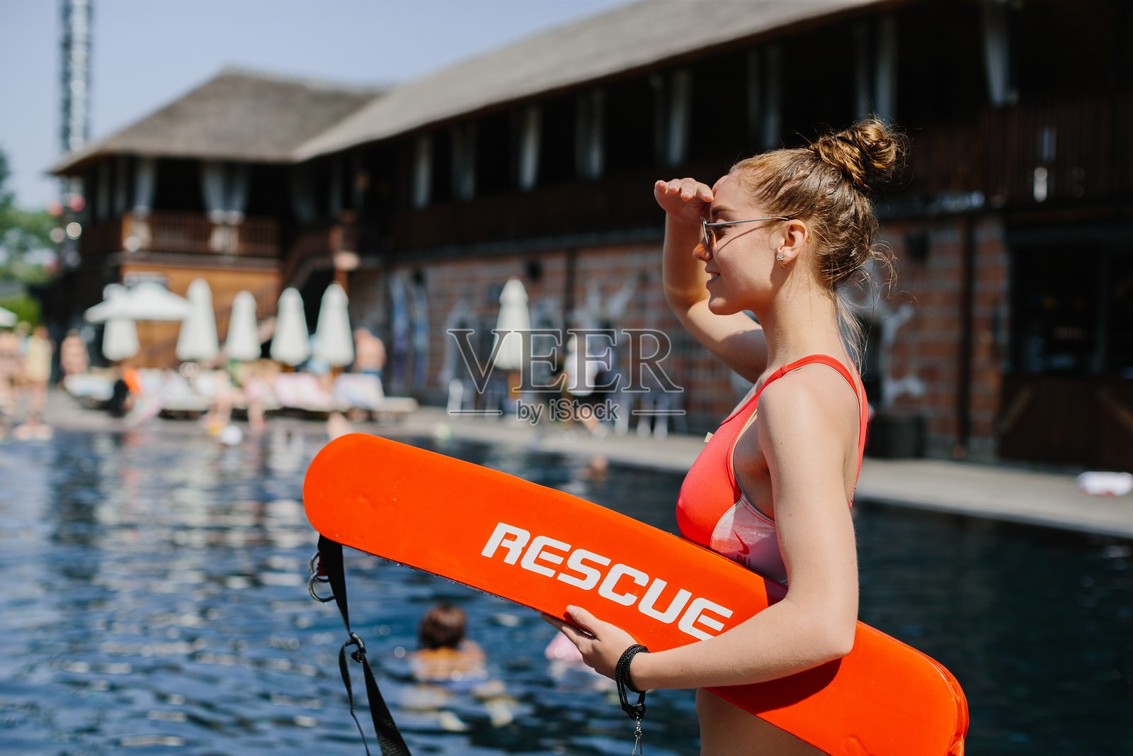 救生员在公共游泳池监视游泳者照片摄影图片