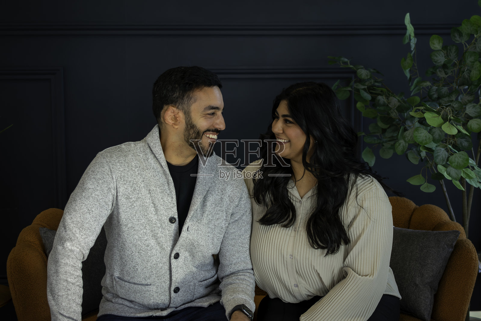 穿着得体的中东亚夫妇在沙发上享受彼此的陪伴照片摄影图片