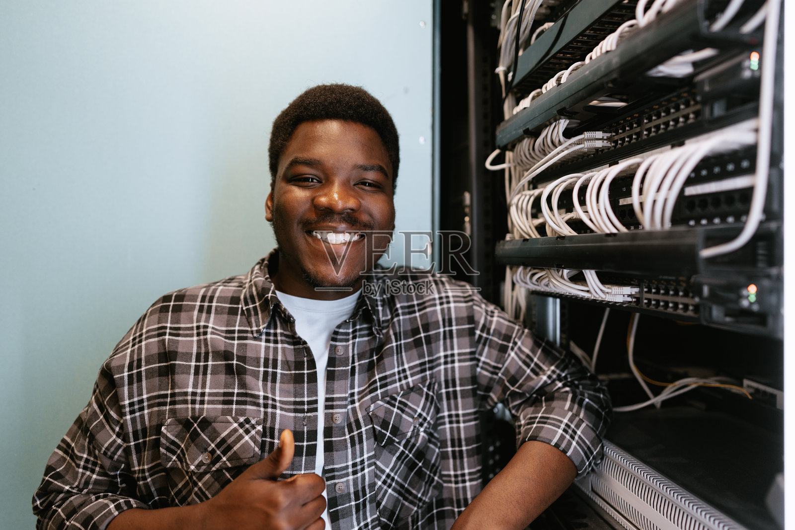 年轻的技术员在服务器机房自信地微笑着工作照片摄影图片