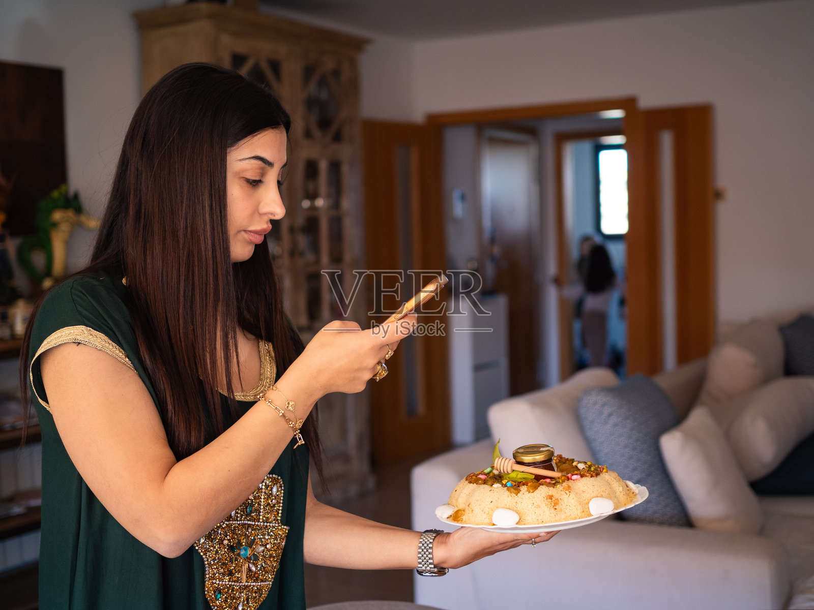 阿拉伯女性在家中拍摄传统菜肴，庆祝文化节日照片摄影图片