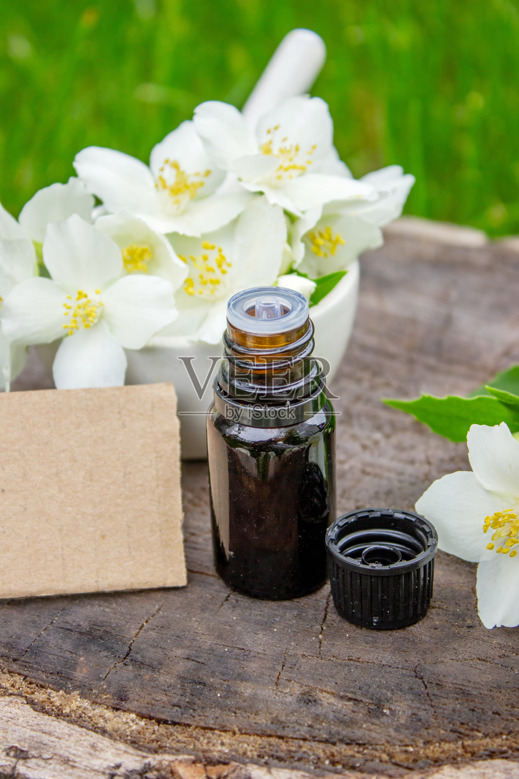 玻璃瓶中的茉莉花精油和茉莉花。油类。照片摄影图片