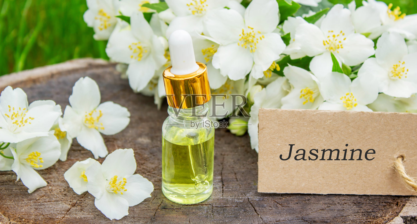 玻璃瓶中的茉莉花精油和茉莉花。油类。照片摄影图片