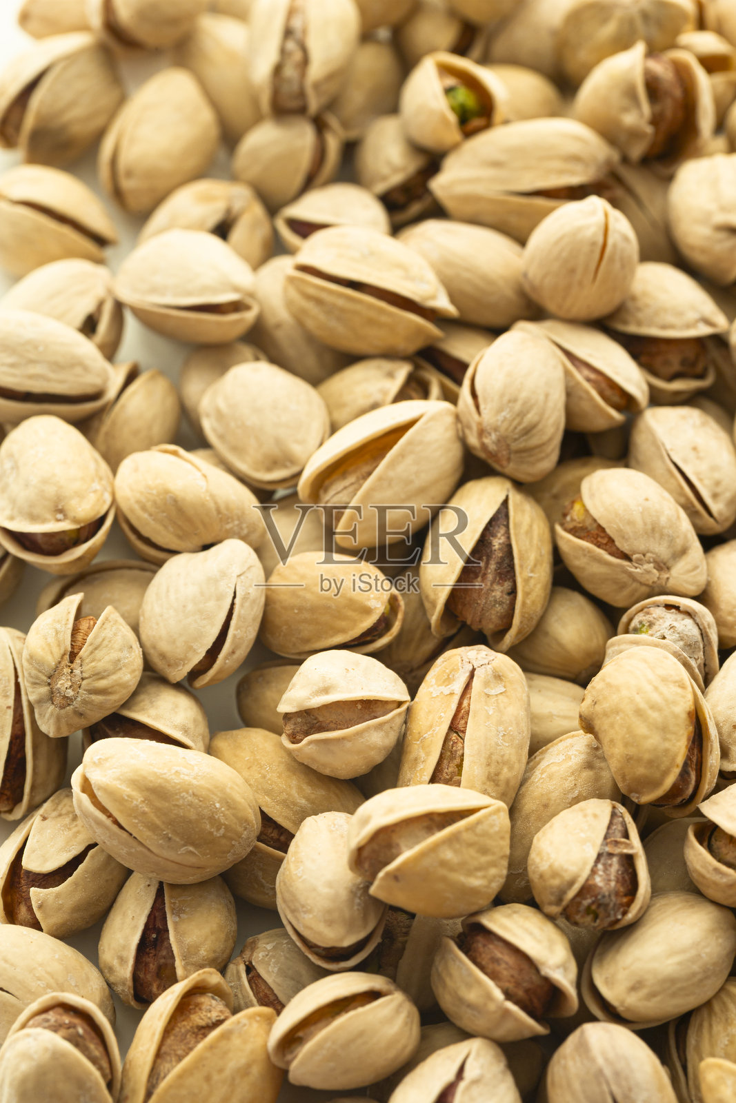 食品概念。极近距离查看新鲜炸制的美味开心果，既有完整的也有磨碎的。照片摄影图片