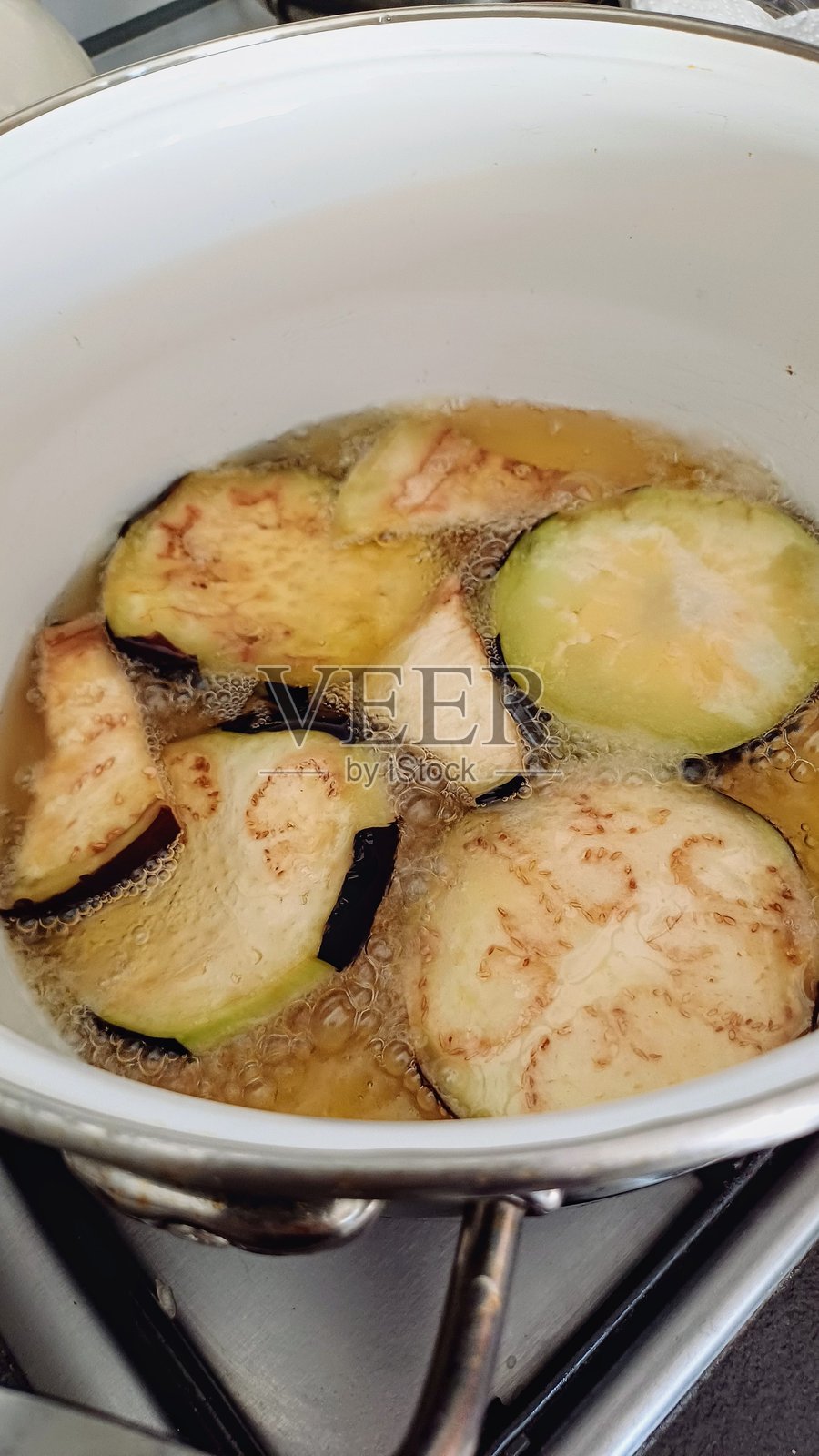 在锅中用大量油煎炸茄子照片摄影图片