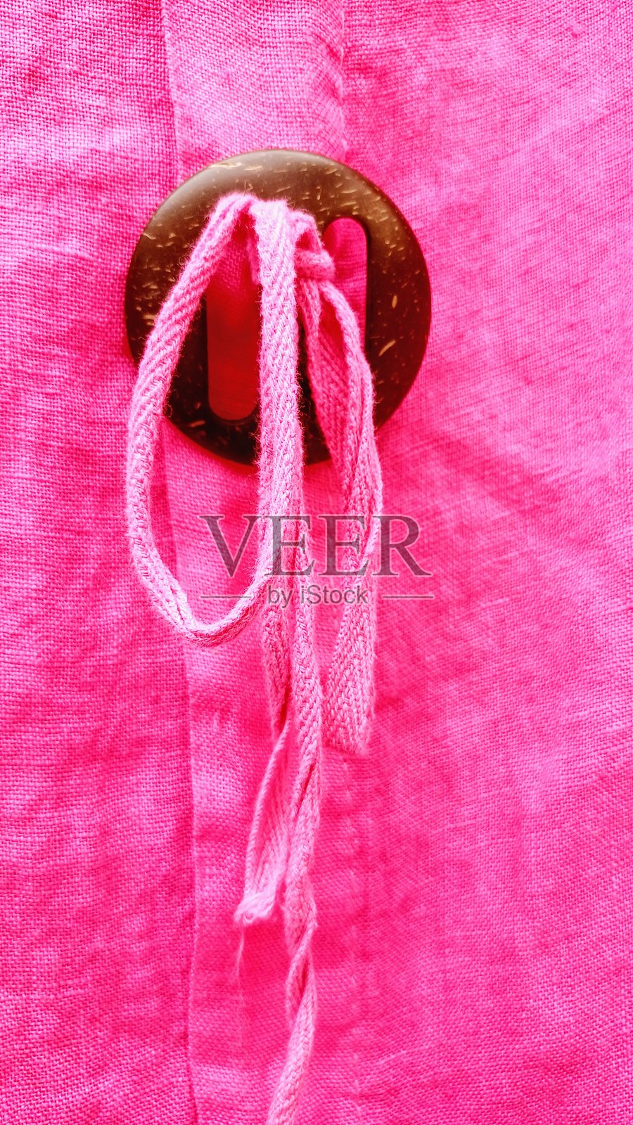 一款粉色夏季女装连衣裙，配有棕色时尚纽扣细节。照片摄影图片