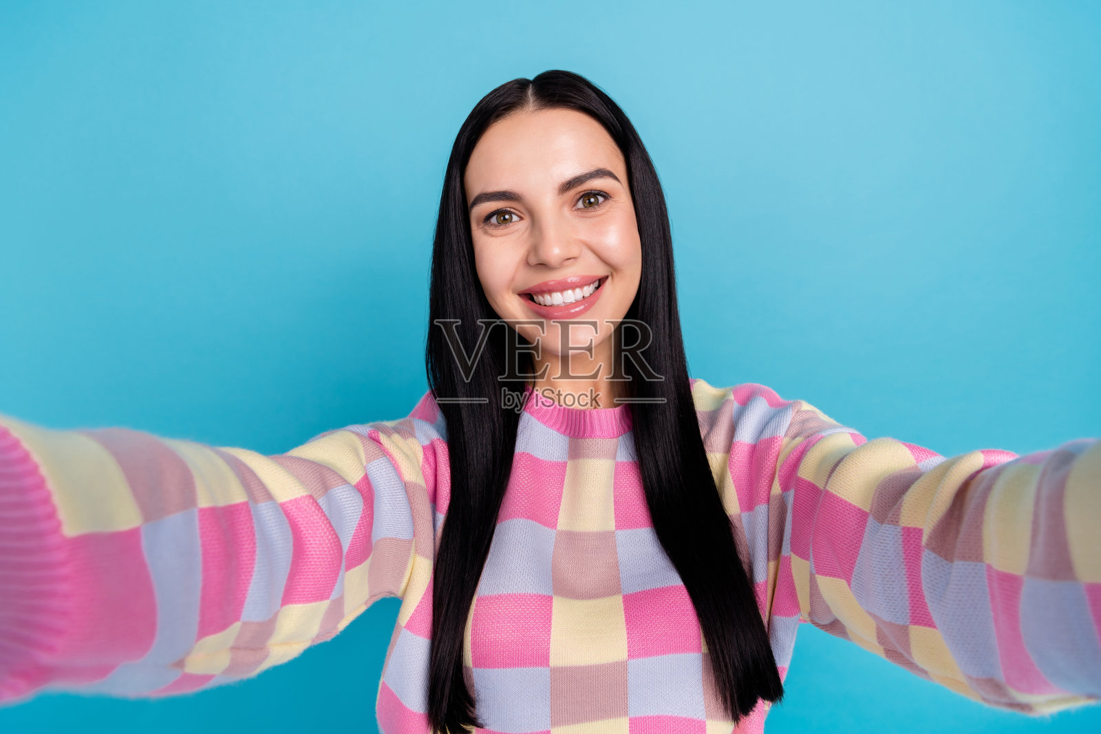 梦幻迷人的年轻女性穿着粉色毛衣在蓝色背景下自拍照片摄影图片