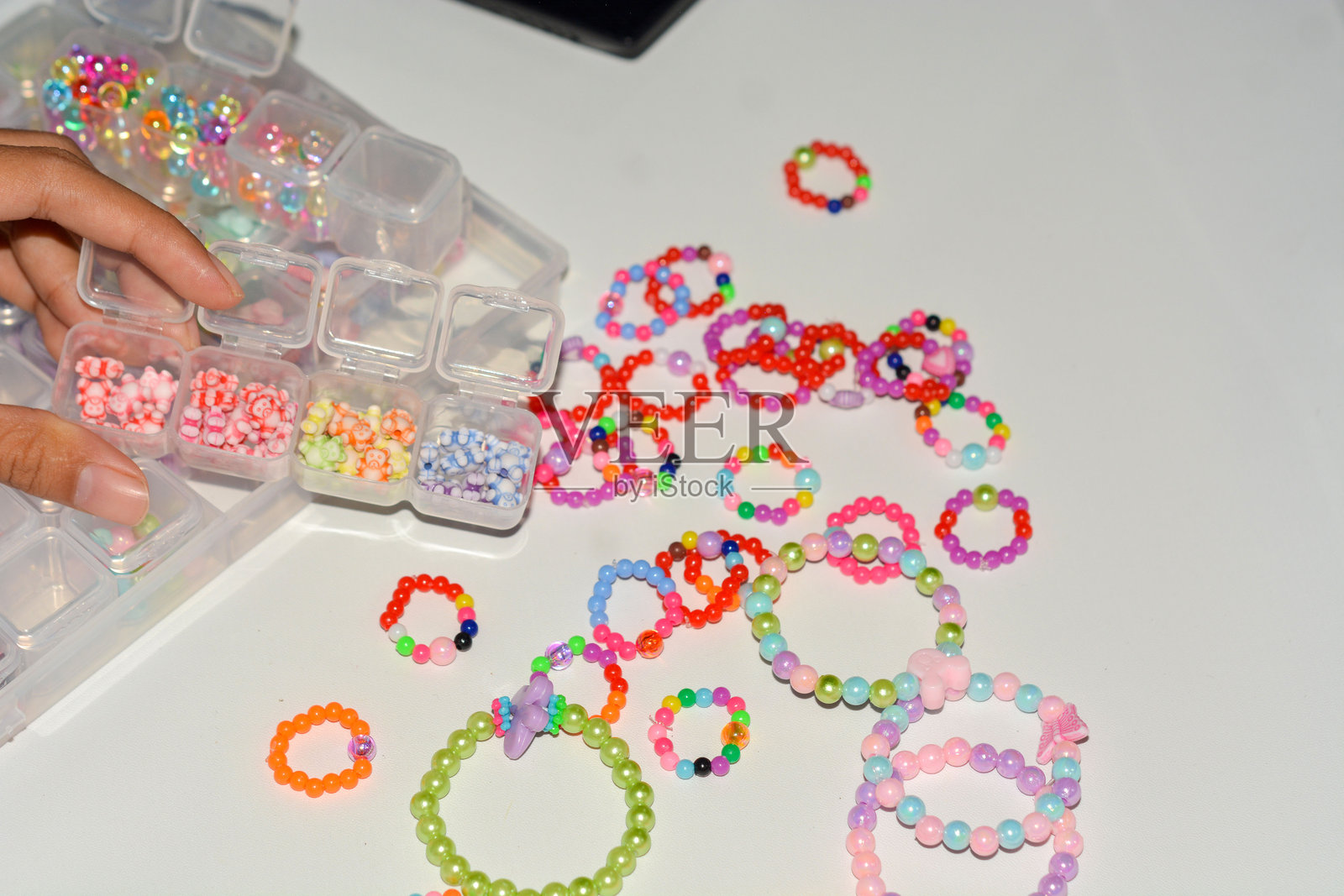 三条珠子儿童手链的特写，背景为白色照片摄影图片