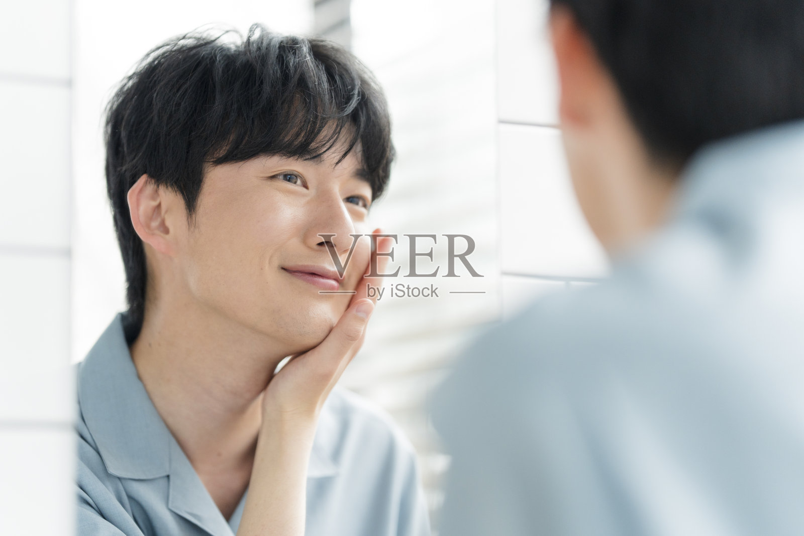 一位年轻的日本男子在家里的浴室里打理自己照片摄影图片