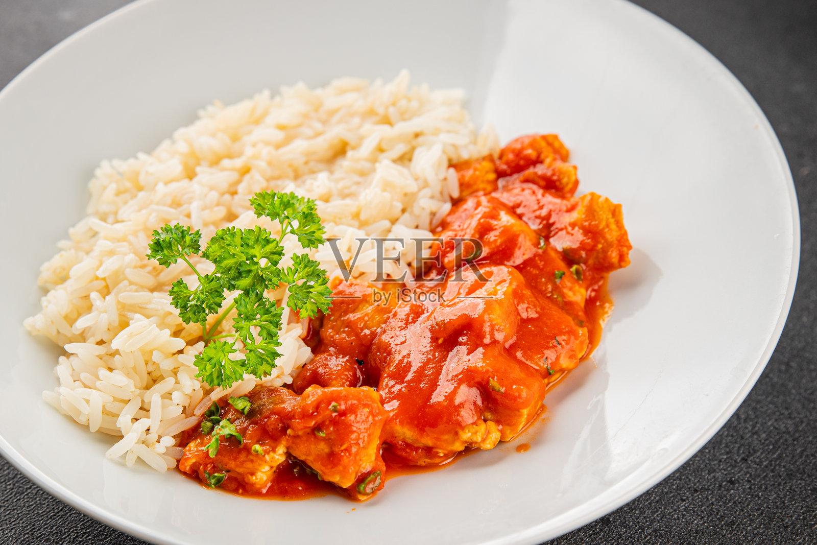 米饭、黄油鸡咖喱、鸡肉提卡马萨拉、碗中的辛辣肉类，桌上的新鲜美味美食背景，乡村风格的食物俯视图，留白空间。照片摄影图片