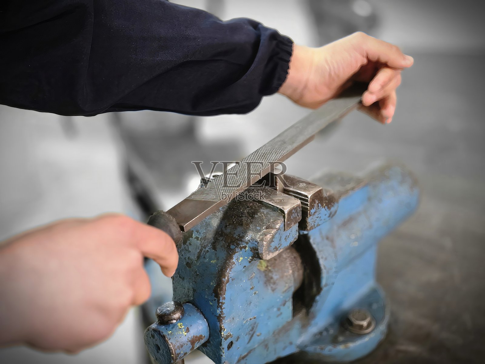 铁匠正在用台钳修整铁件照片摄影图片