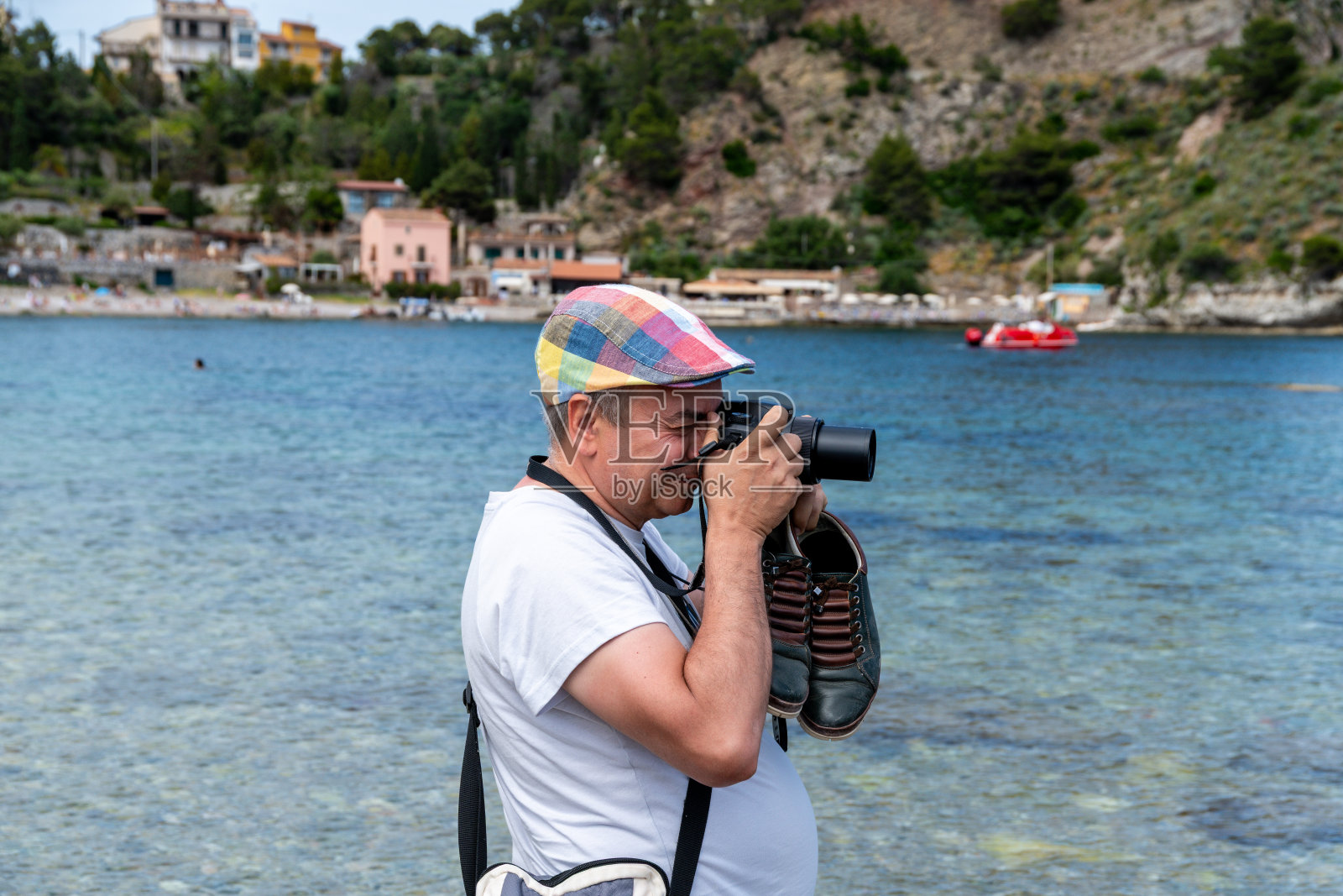 在伊索拉贝拉海岸线的摄影师与鞋子照片摄影图片