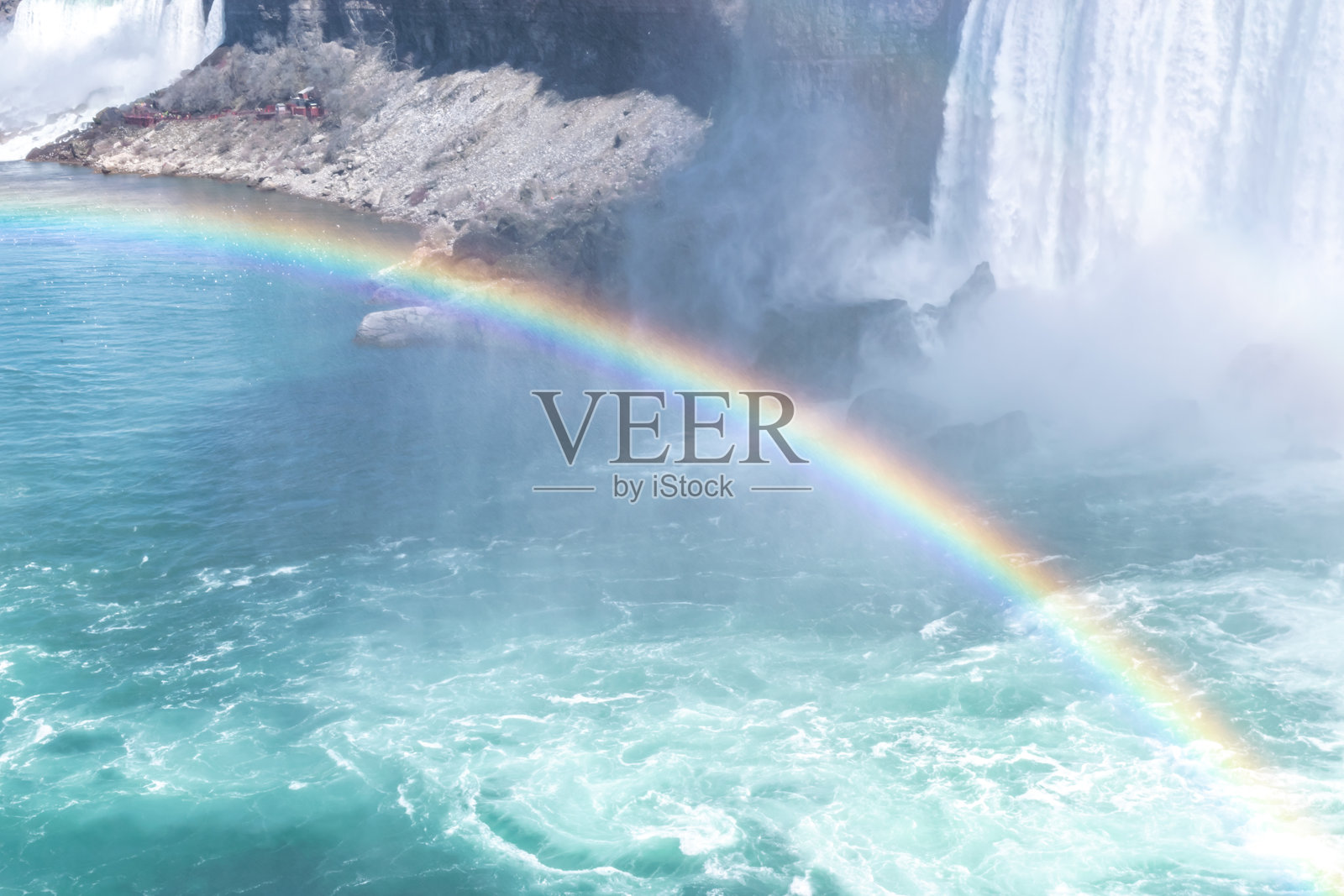 美丽的马蹄瀑布景观，游船上有游客和彩虹。照片摄影图片