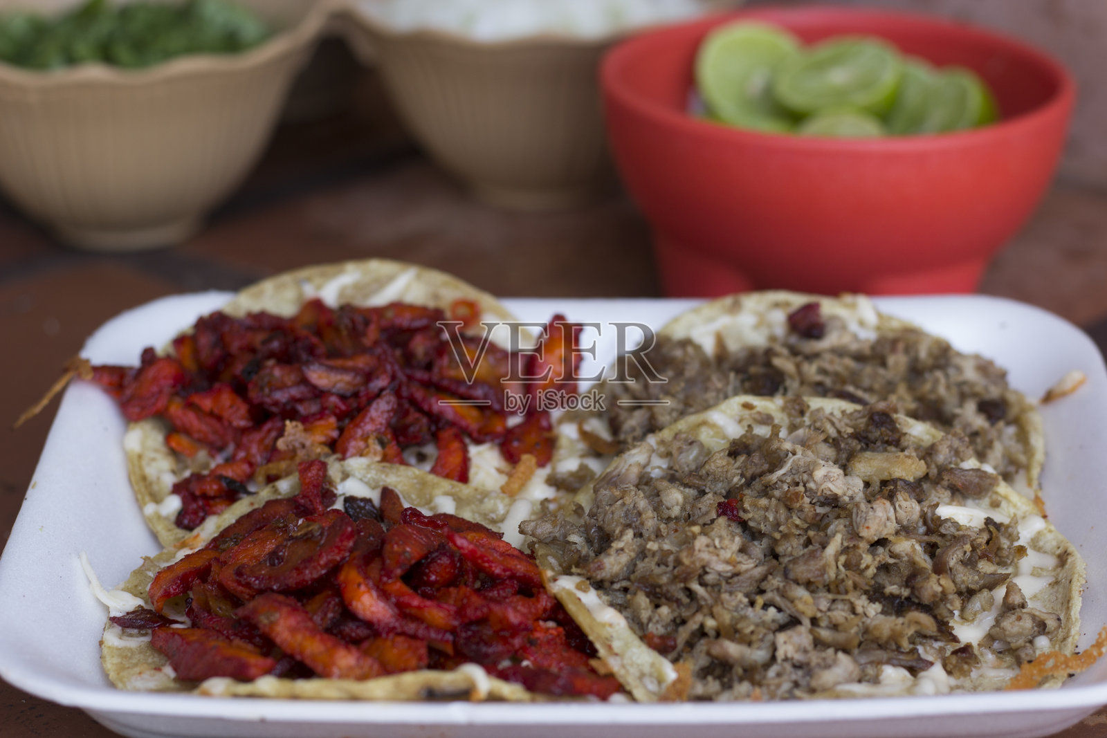 色彩鲜艳的盘子，上面摆放着美味的玉米饼，里面填满了多汁的猪肉和牛肉照片摄影图片