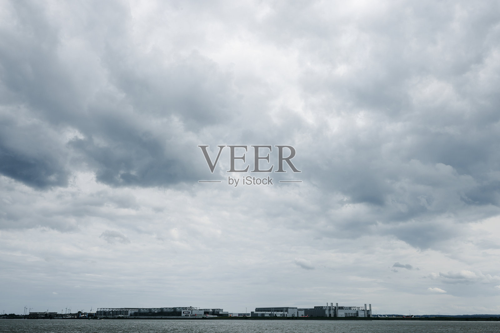 2025年6月5日，德国汉堡。阴郁天气下，从布兰肯泽俯瞰芬肯维尔德的空客飞机制造综合体，位于易北河畔。照片摄影图片