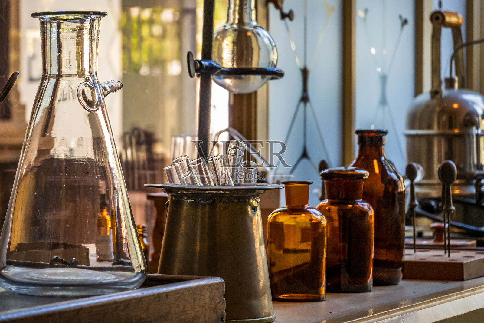 复古实验室场景，桌上陈列着各种玻璃器皿和瓶子，营造出古典氛围。照片摄影图片