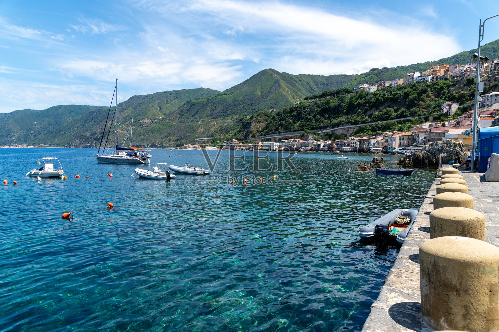 海滨村庄，背景是山脉和船只照片摄影图片
