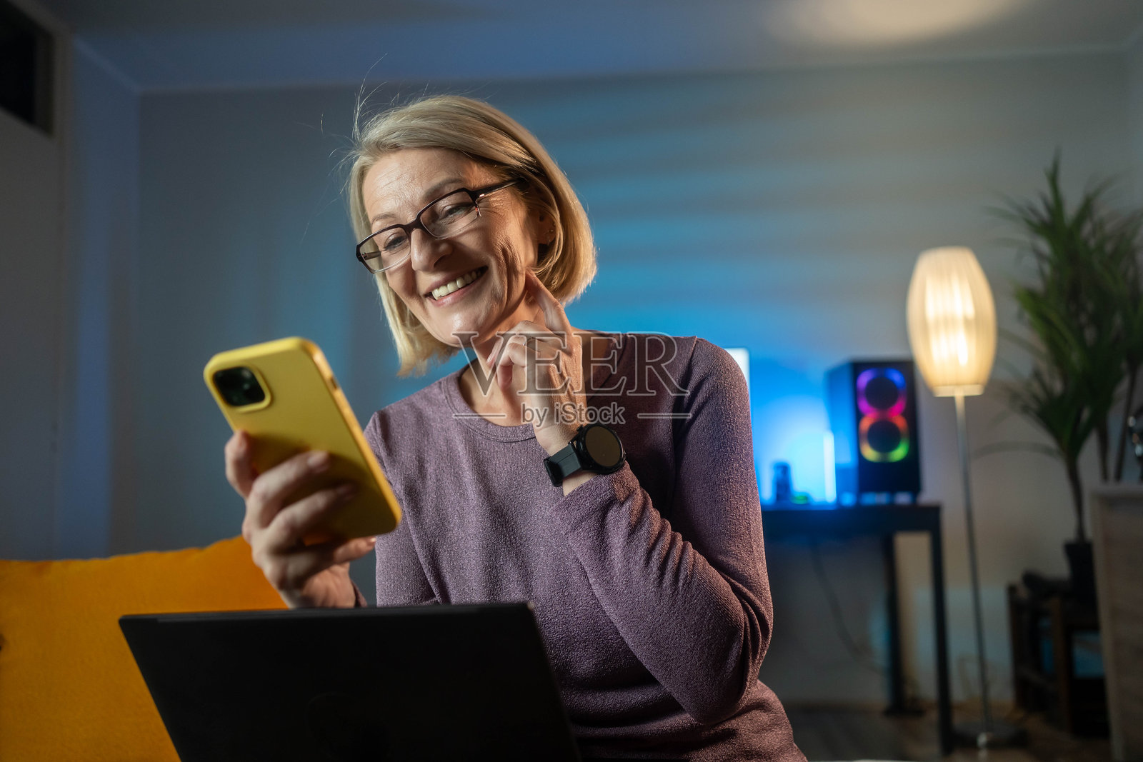 一位成熟的女性正在使用手机阅读最新新闻。照片摄影图片