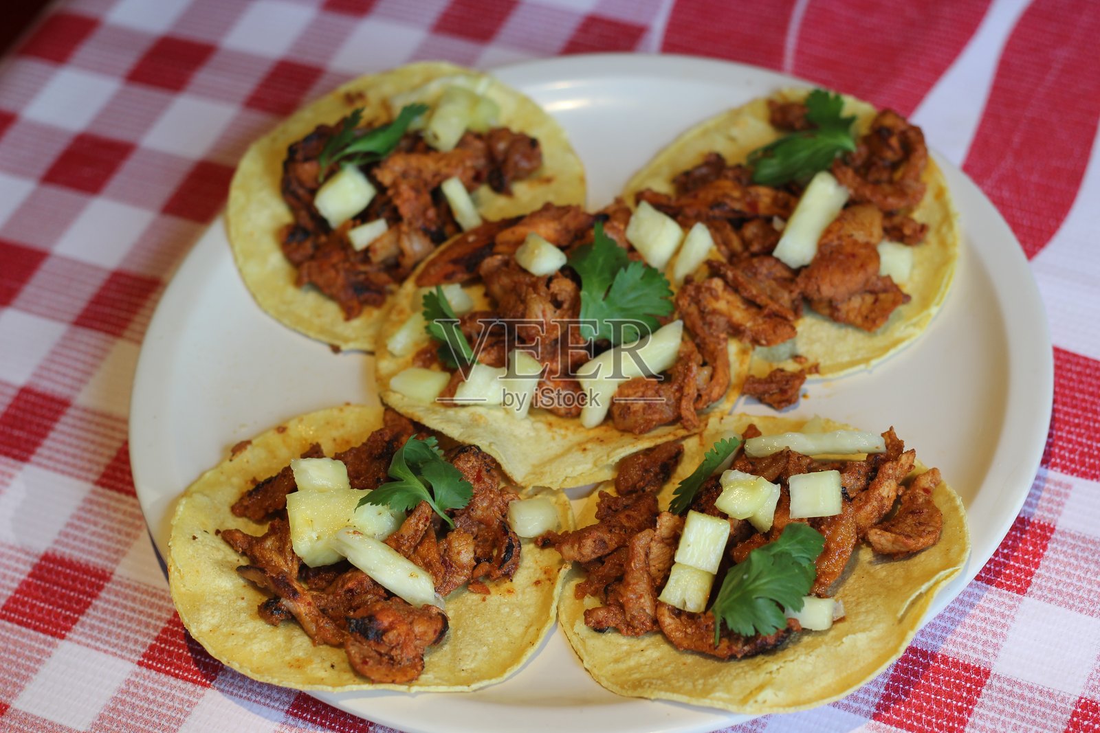 一盘色彩鲜艳、美味的阿尔帕斯托塔可，配有新鲜的菠萝和香菜。照片摄影图片