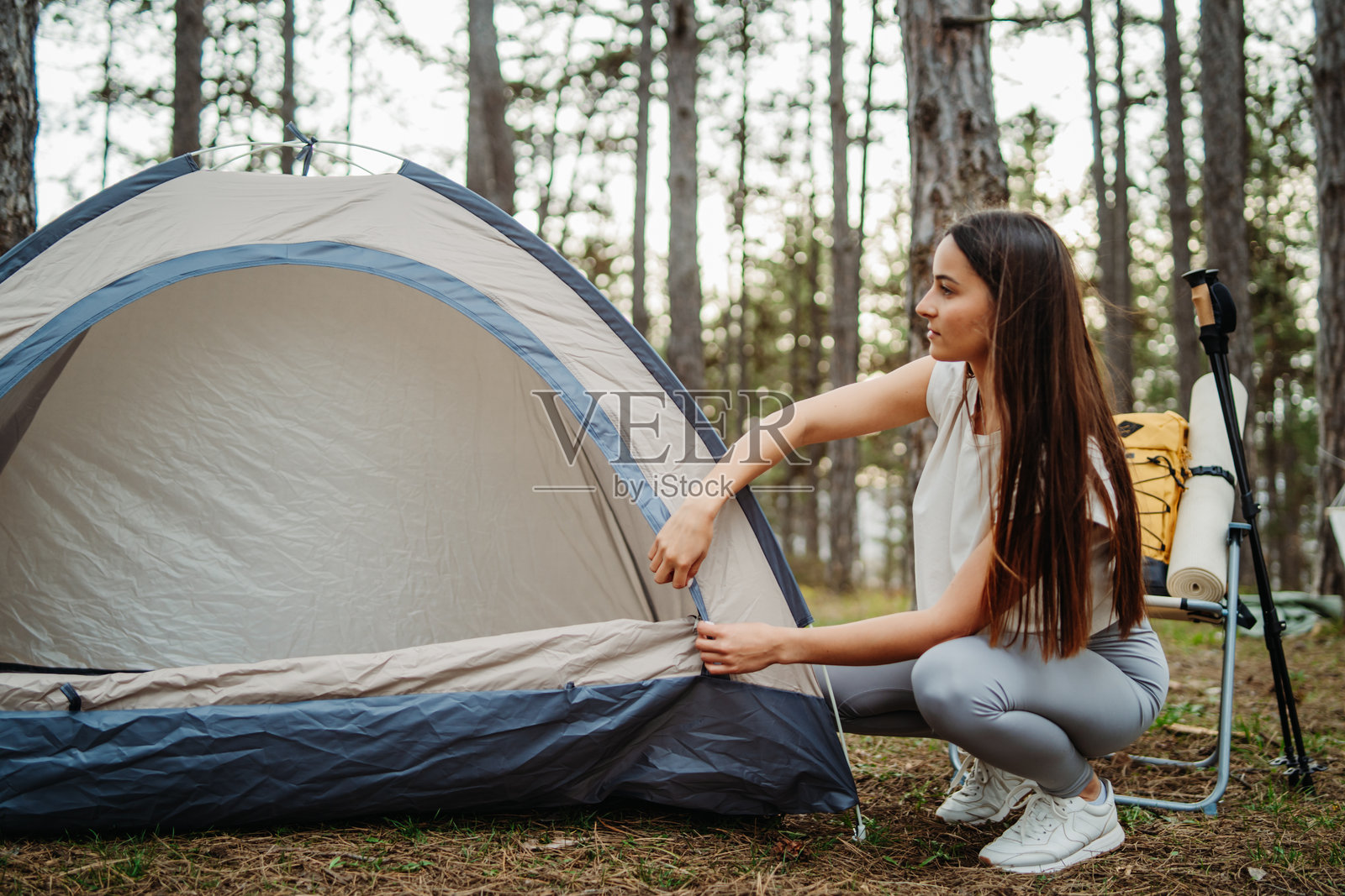 年轻的白人女性在风景如画的森林中为夜晚准备营地和篝火照片摄影图片