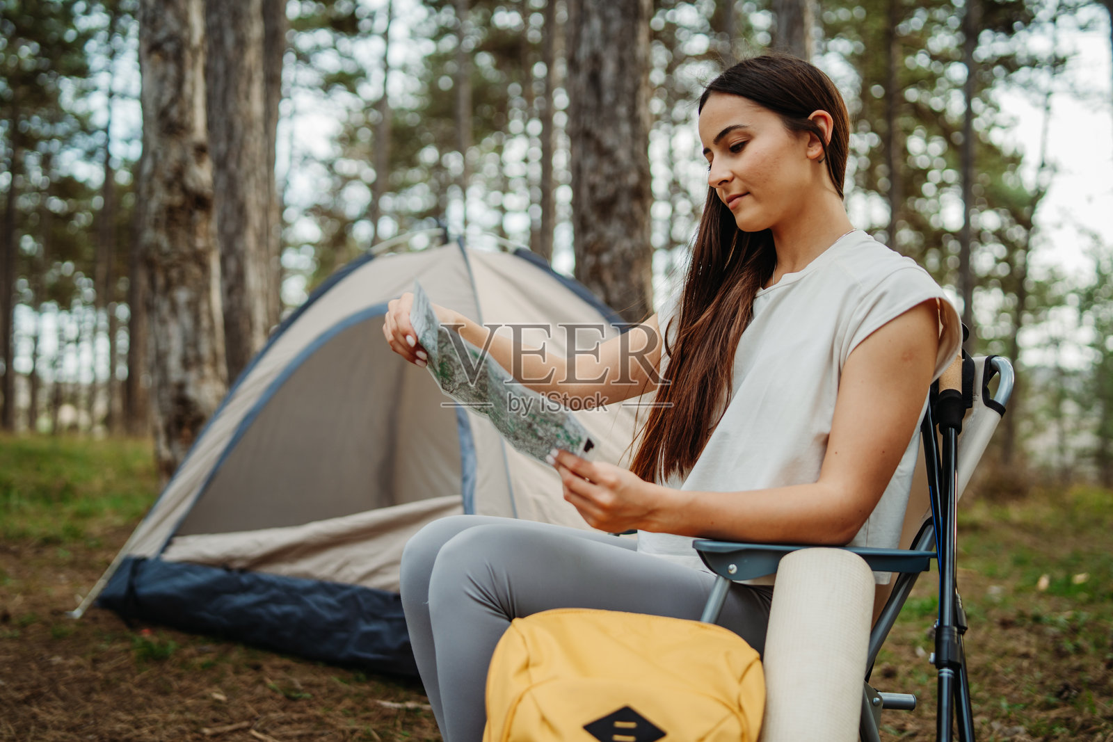 年轻的白人女性在风景如画的森林中为夜晚准备营地和篝火照片摄影图片