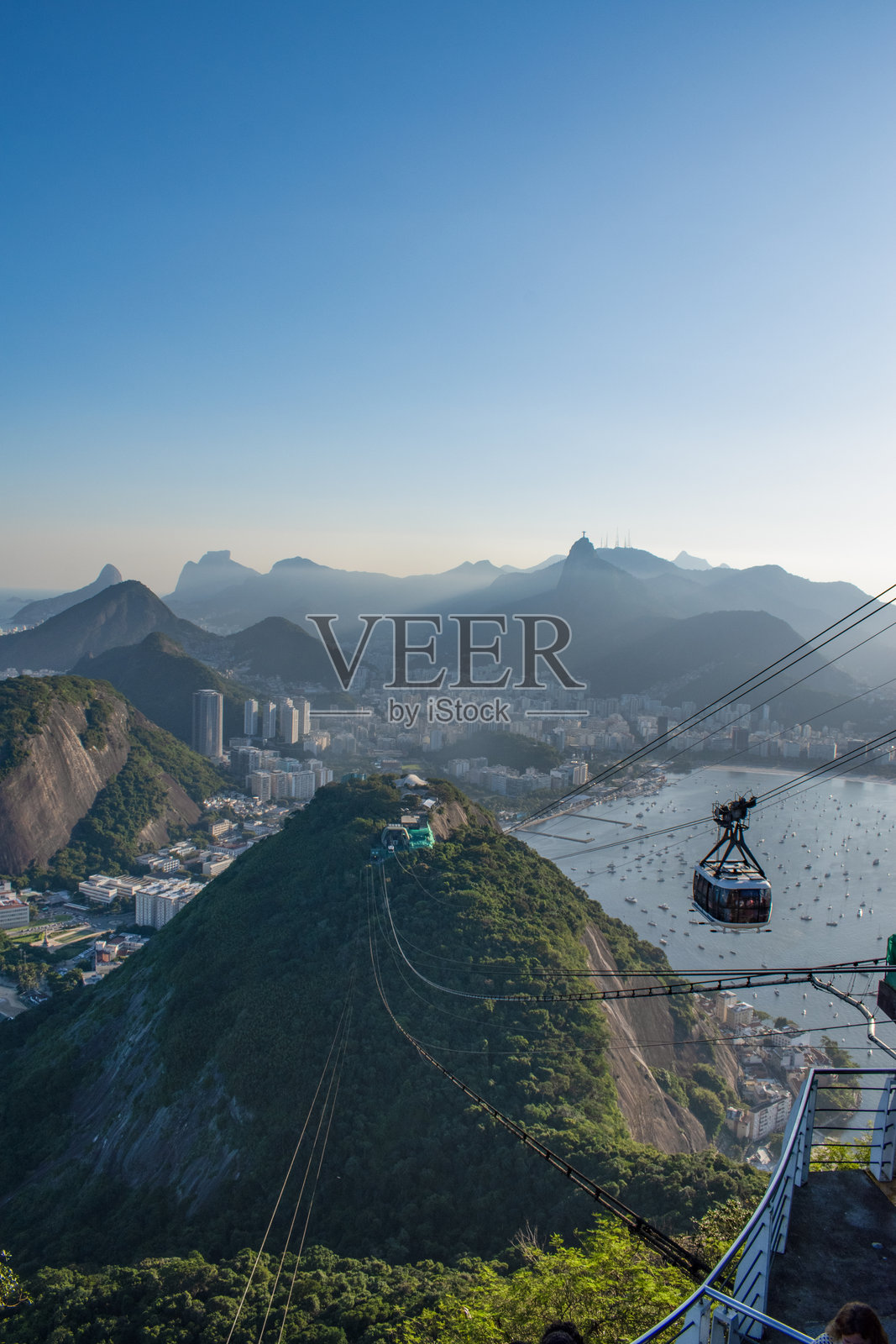 巴西里约热内卢：从糖面包山缆车上俯瞰城市天际线的壮丽全景，耶稣基督救世主雕像位于科尔科瓦多山上照片摄影图片