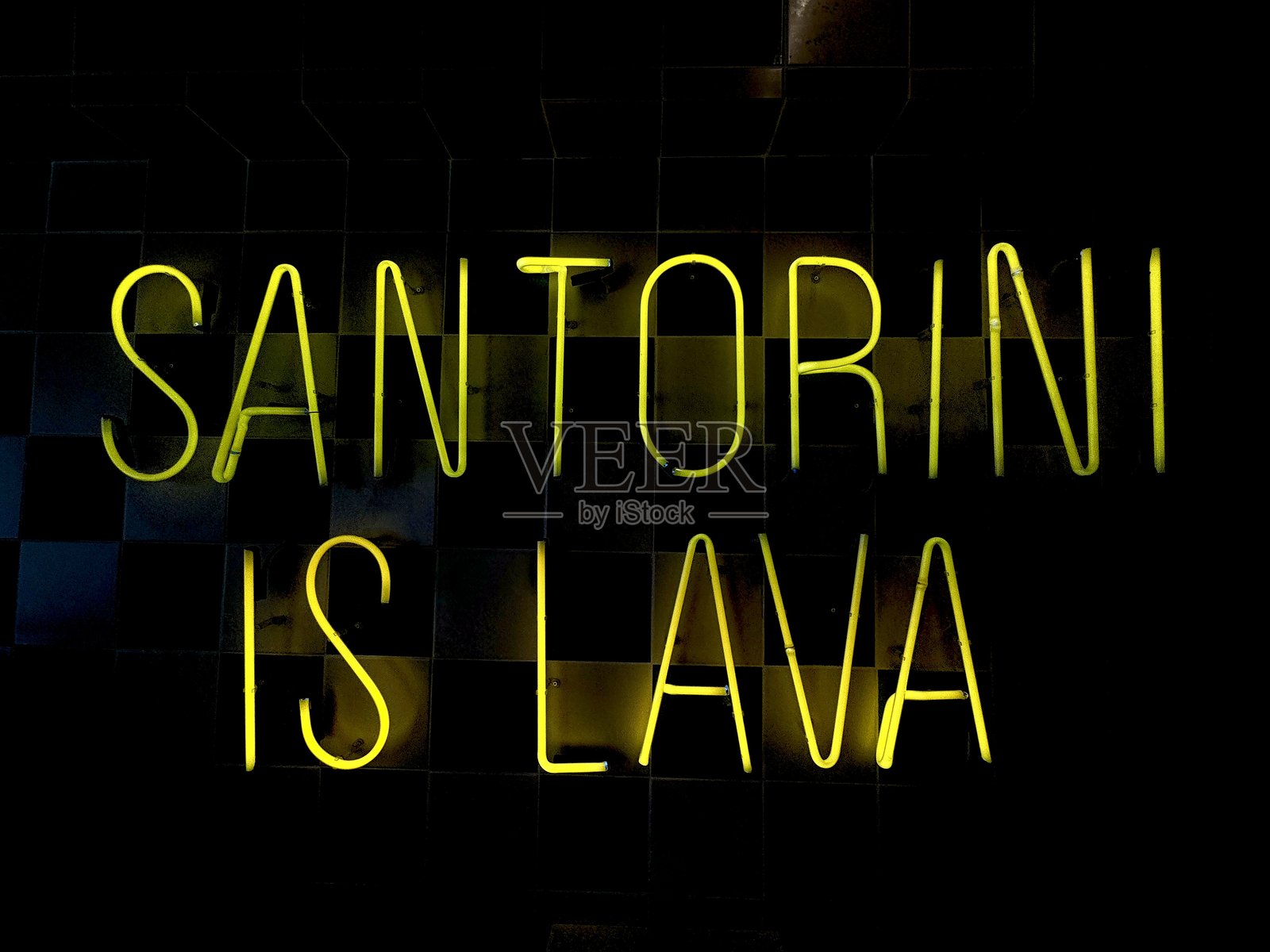 圣托里尼是熔岩 - 明亮的黄色霓虹灯牌上写着照片摄影图片