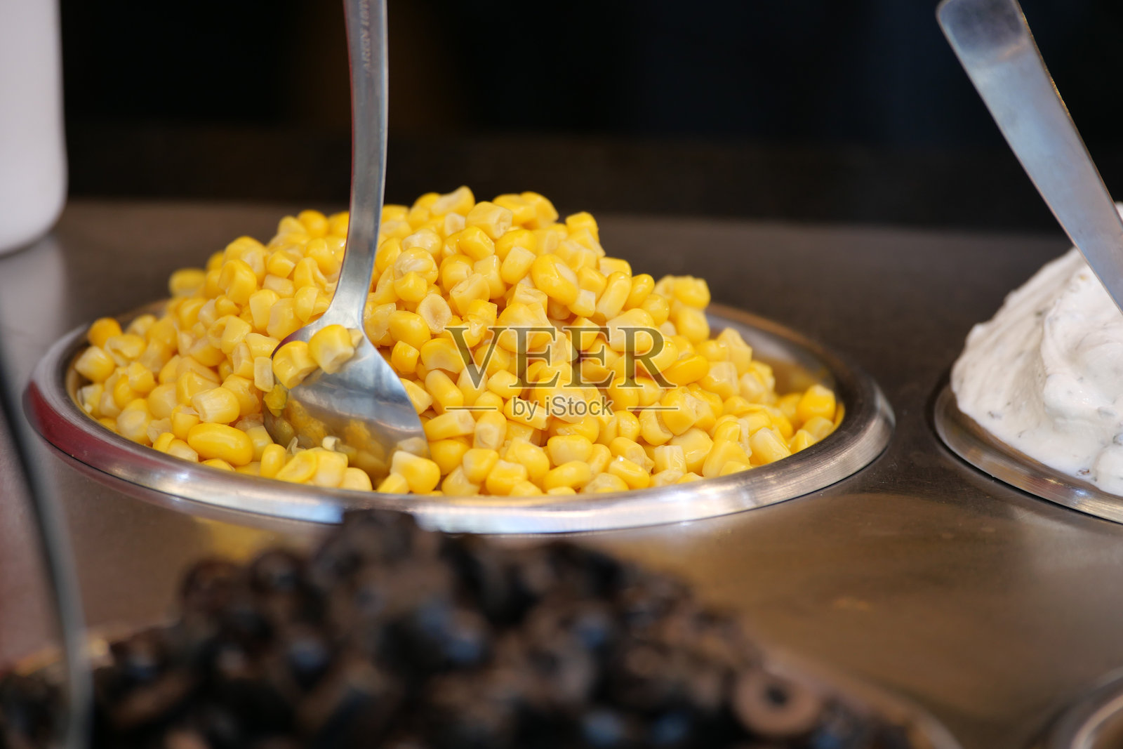 在食品摊位上用金属碗盛放的甜玉米照片摄影图片