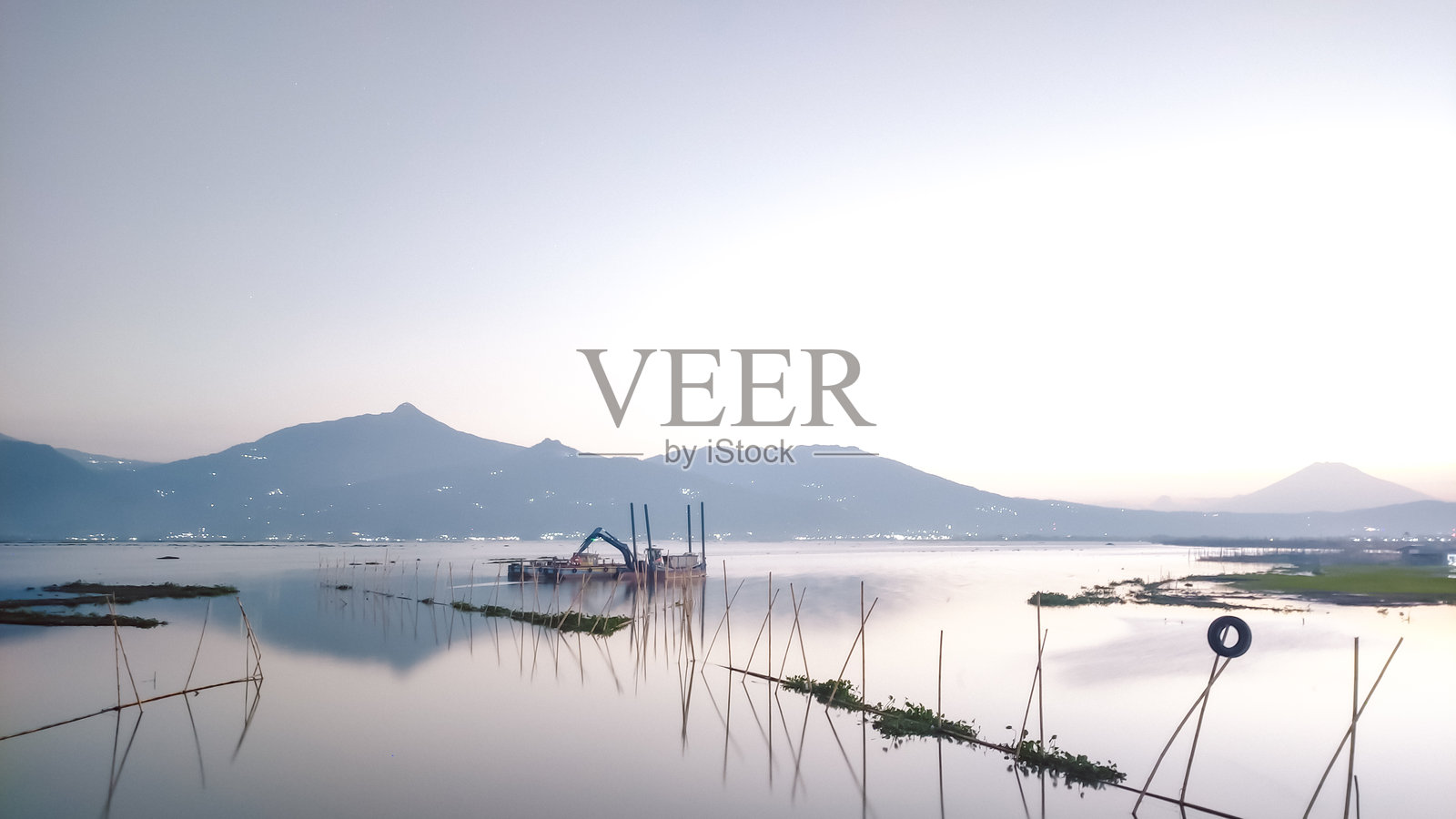 宁静的拉瓦佩宁湖畔黎明，远处的特洛莫约山和宁静的湖水照片摄影图片