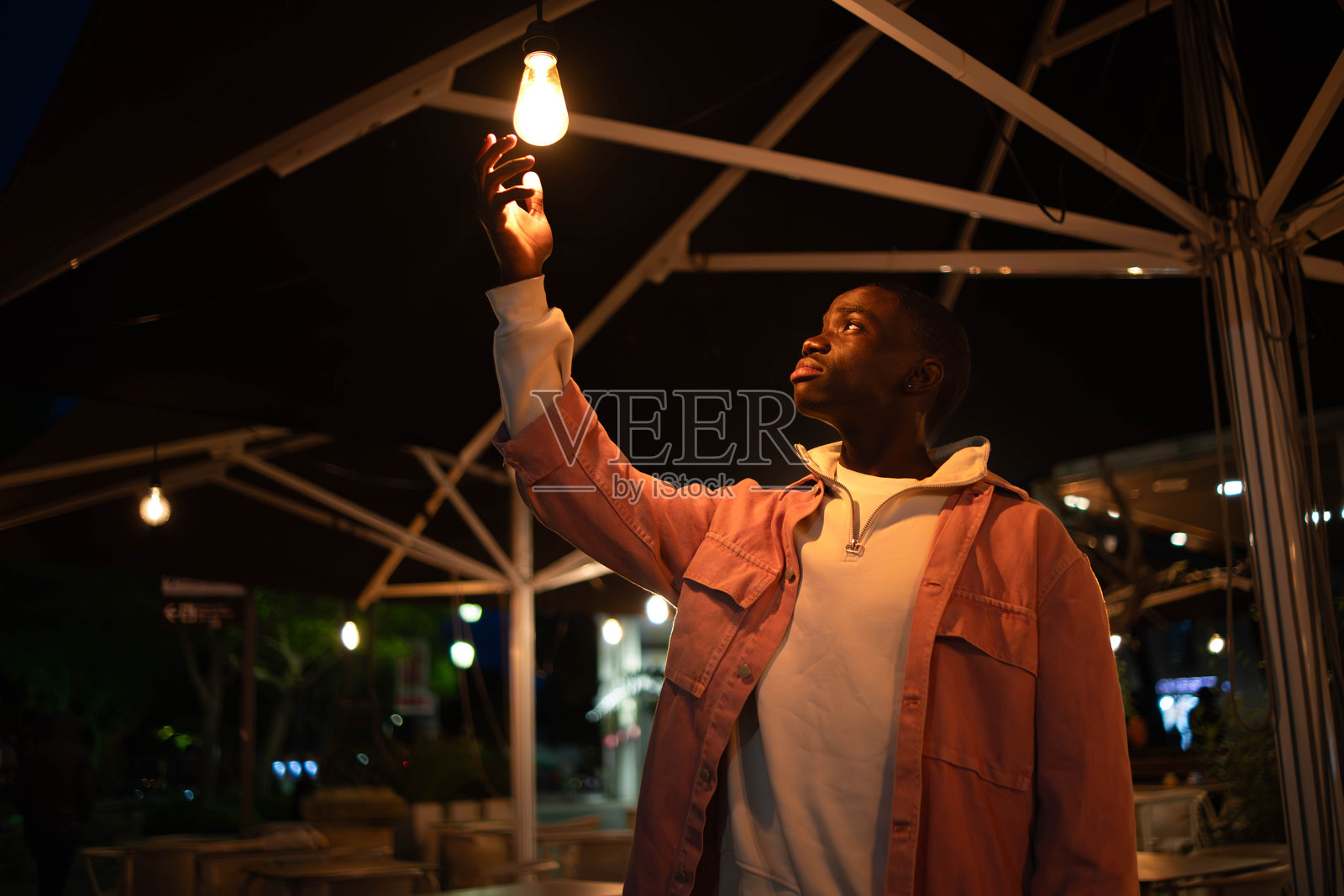 年轻的黑人男子在葡萄牙塞图巴尔触摸一盏灯照片摄影图片